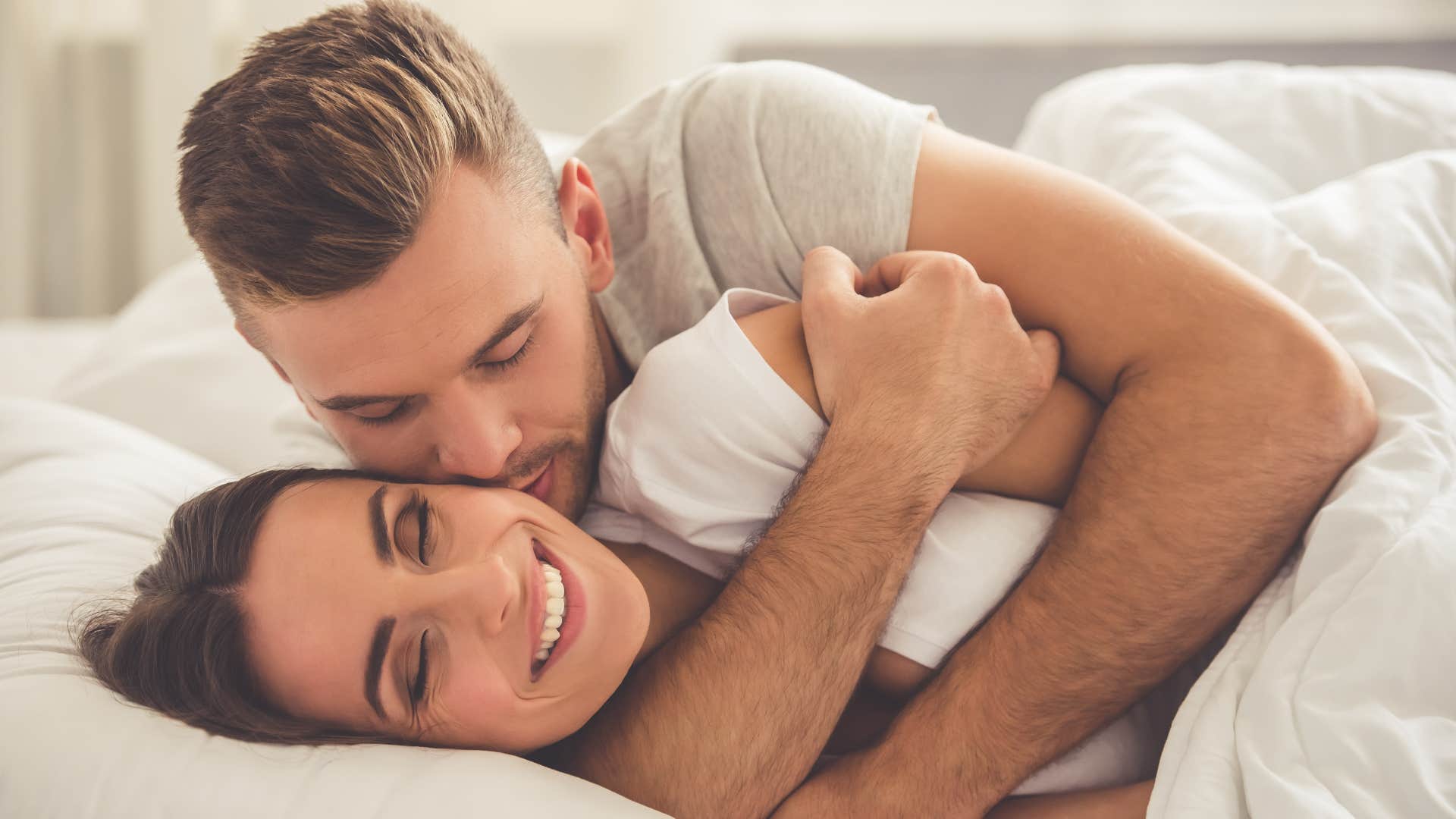 Couple cuddling in bedroom with no TV