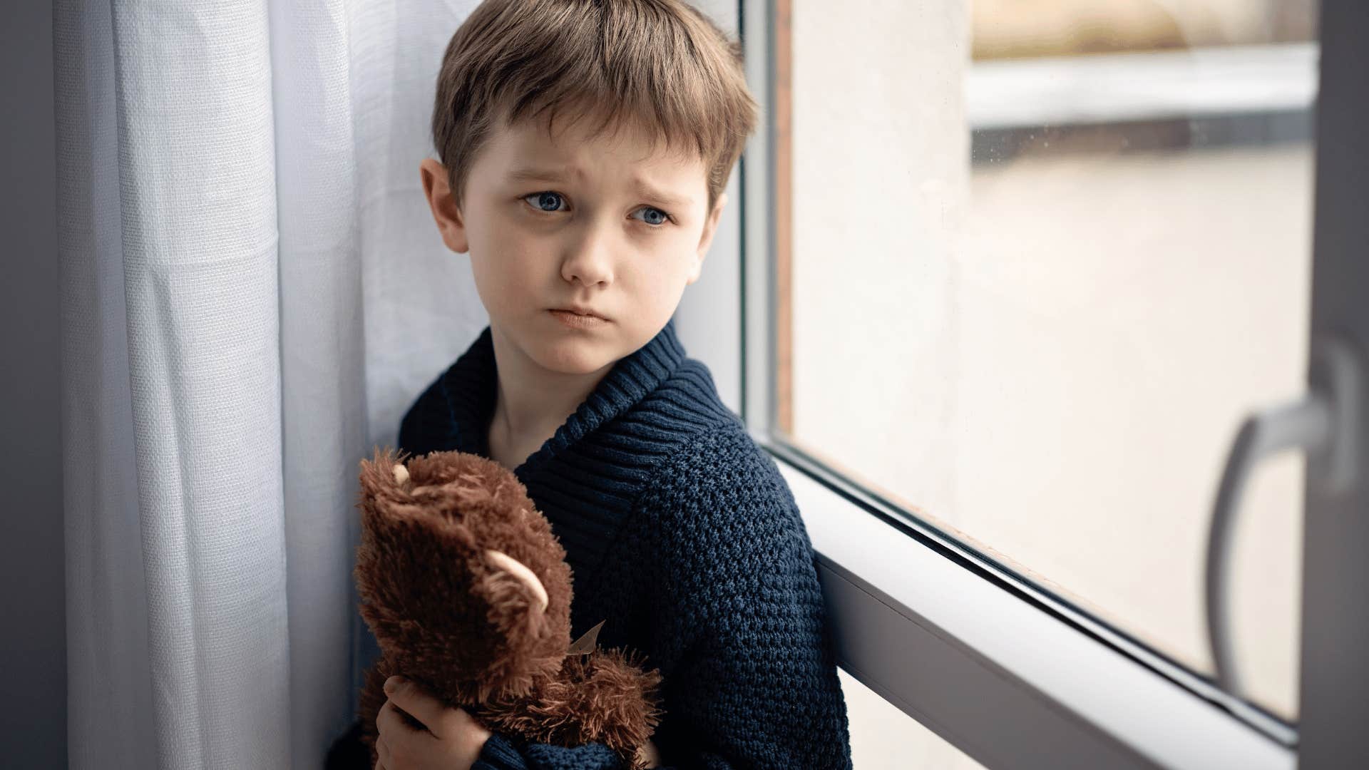 neglected child holding teddy bear