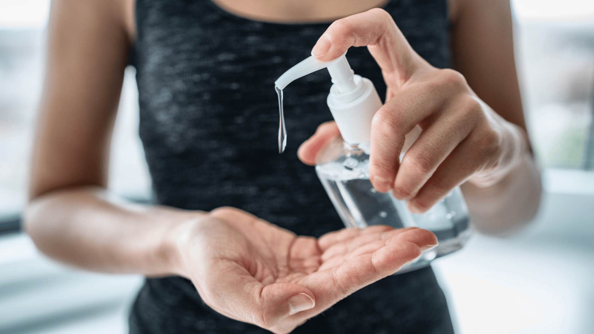 Hand sanitizer woman applying sanitizing gel liquid rubbing hands clean