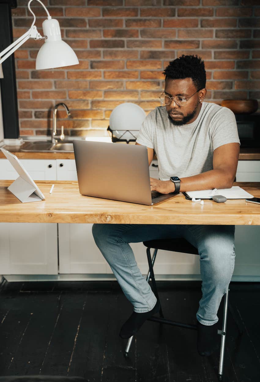 man applying for jobs at desk on laptop