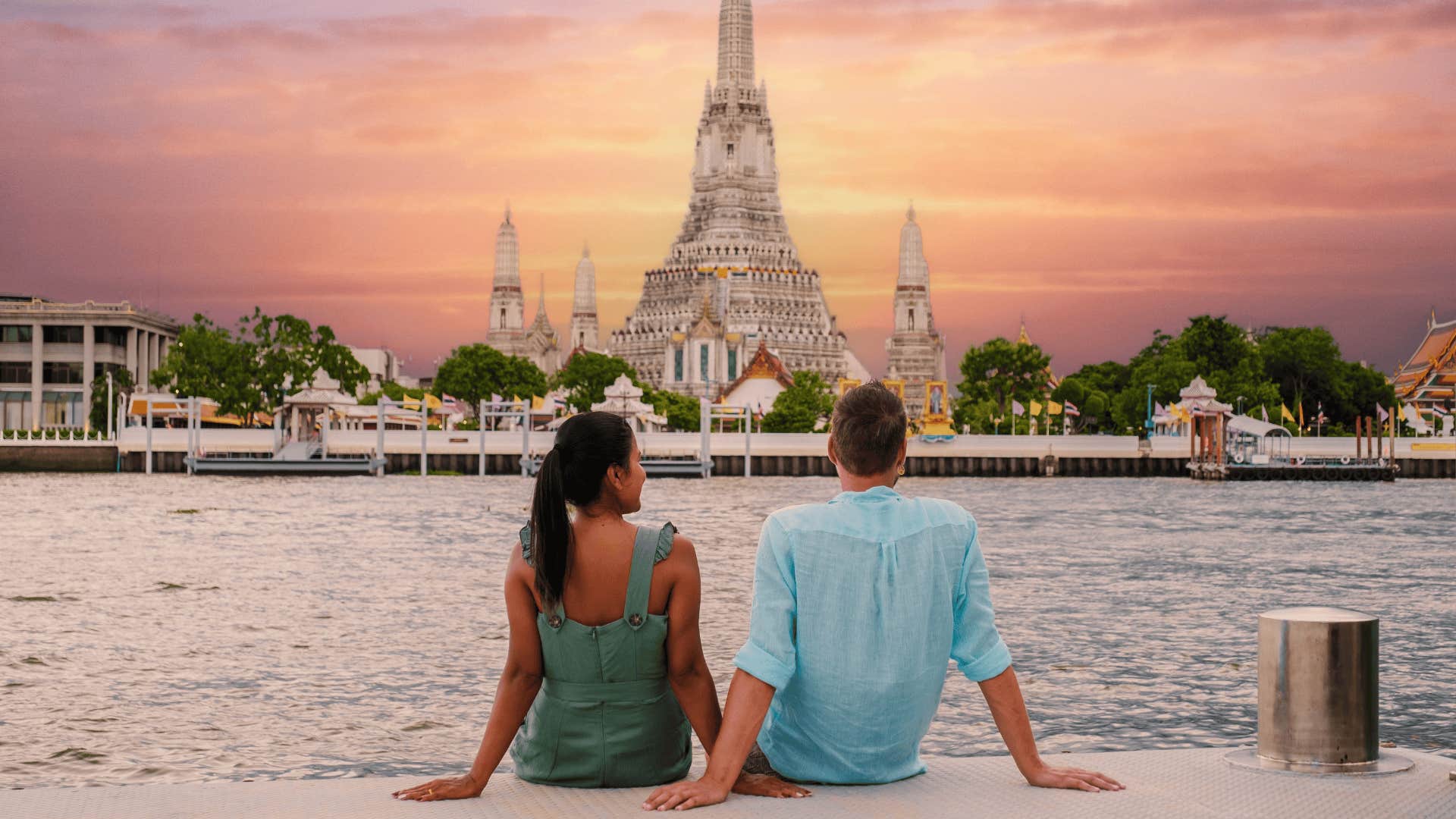 couple in Thailand watching sunset by the river