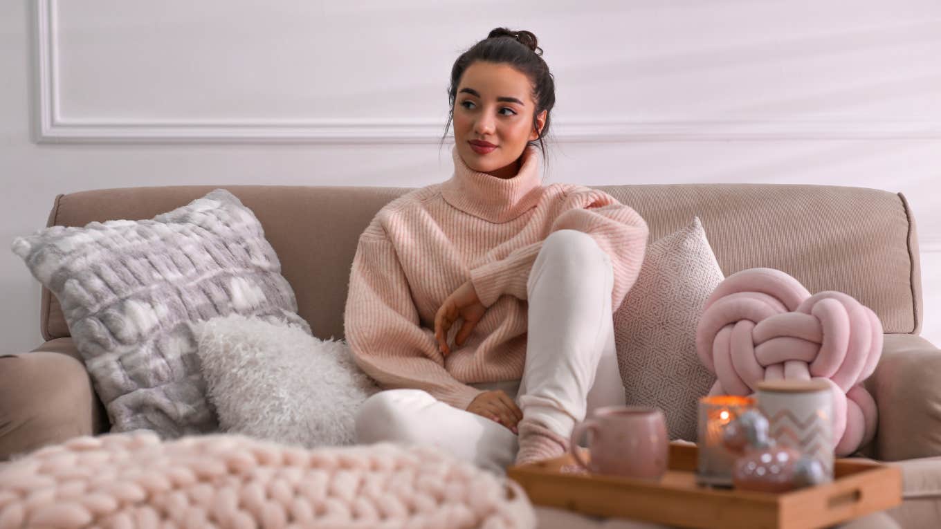 Woman sitting on her cozy couch in her living room