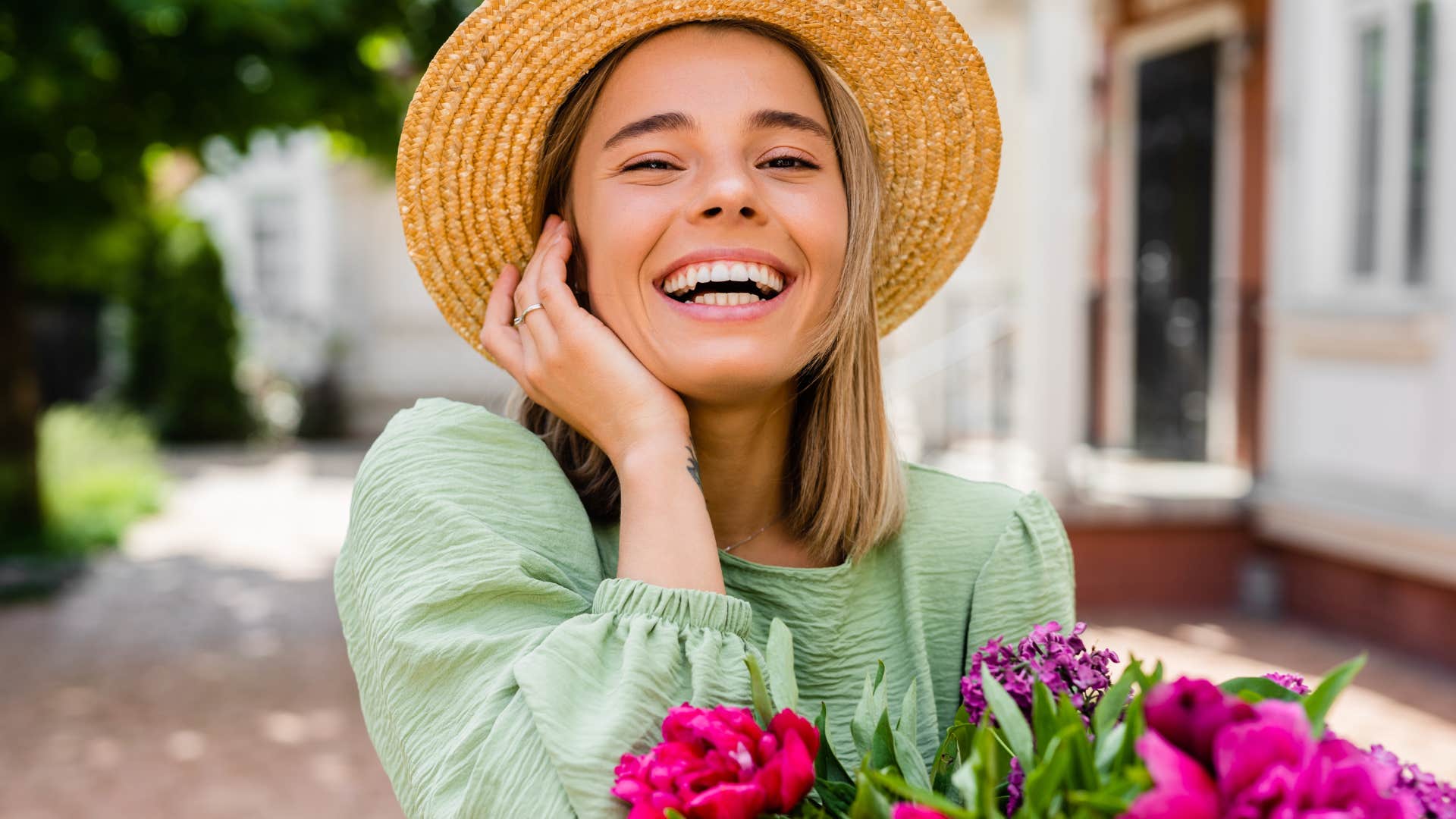 Happy woman laughing holding flowers