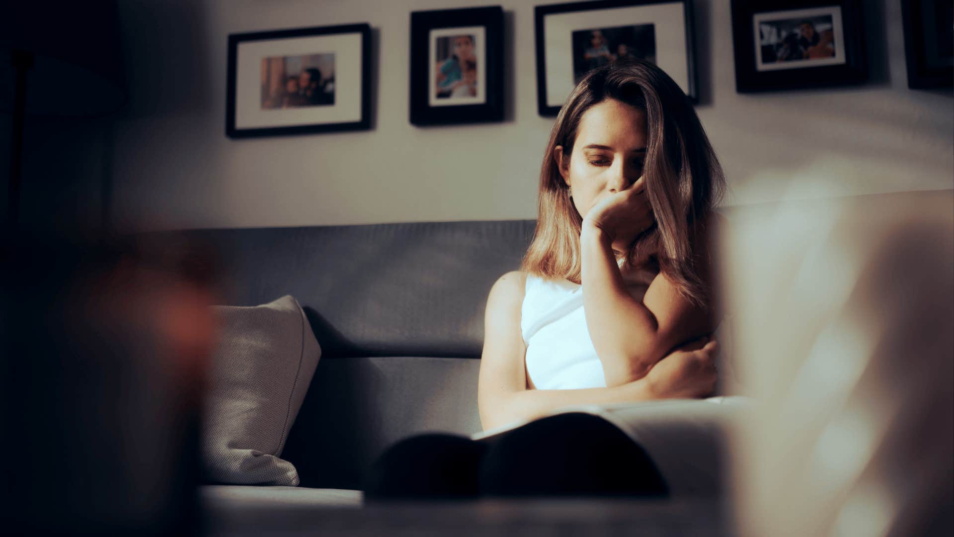 Sad Depressed Woman Alone at Home Sitting on a Sofa