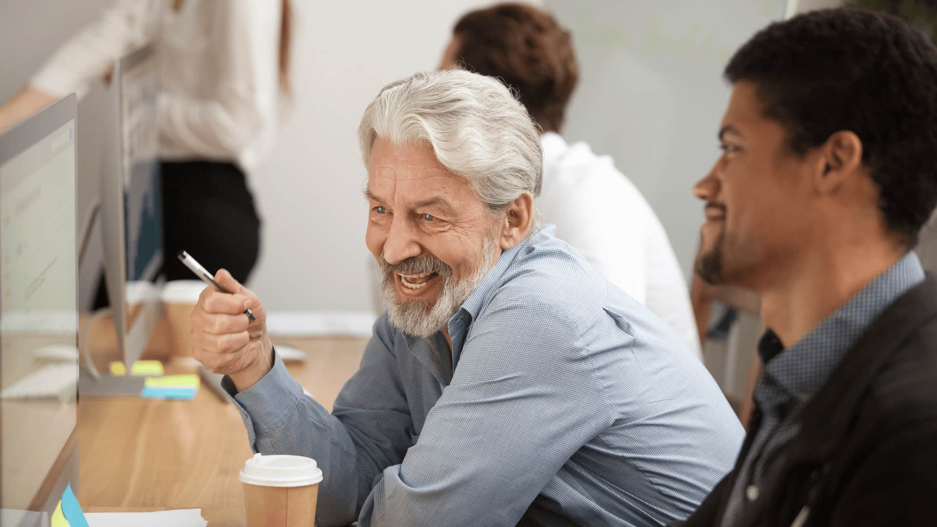 older man working with group of people