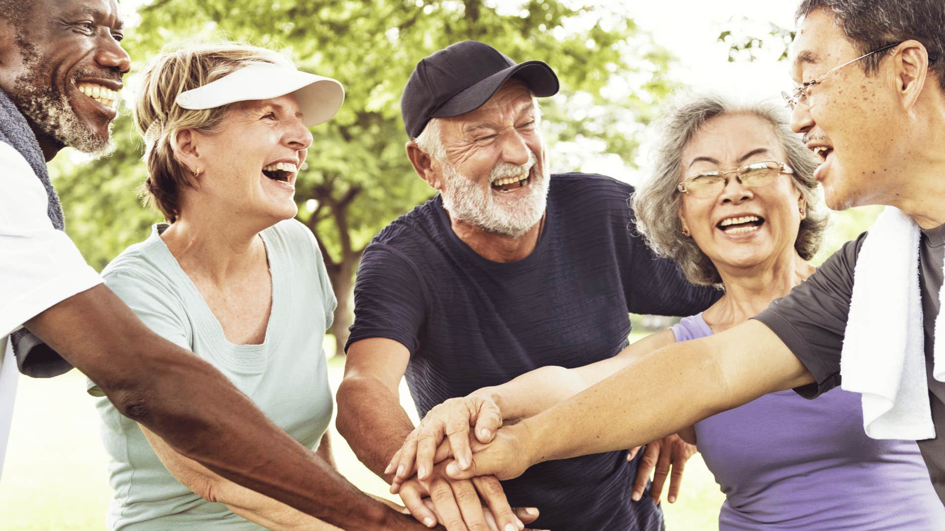 older people putting their hands in the middle