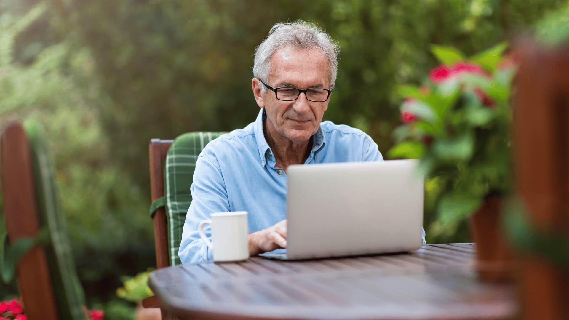 older man on laptop outside