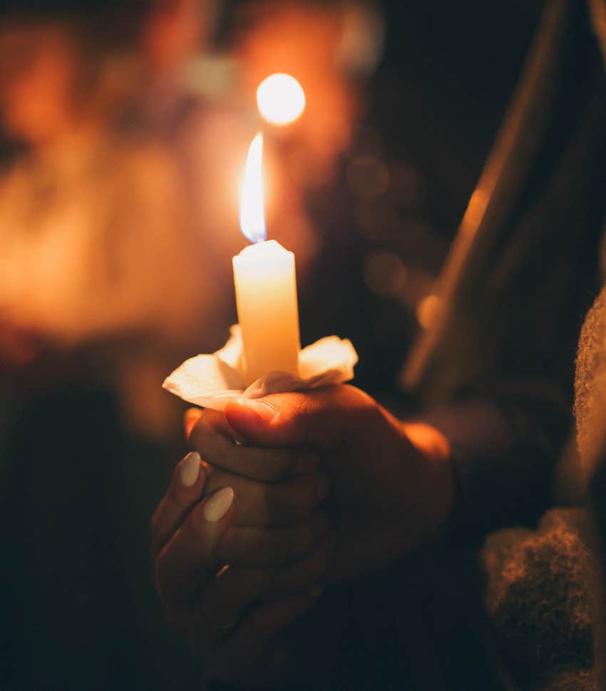 Hand holding burning candle