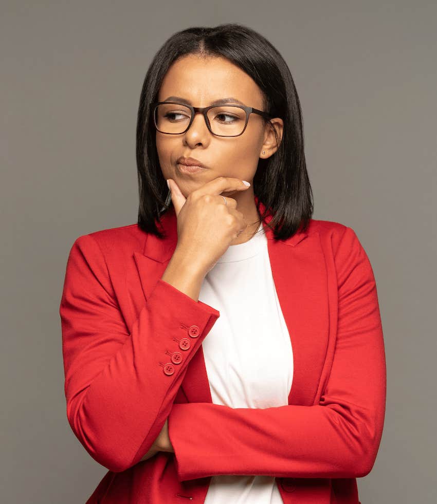 Woman holds chin and wonders about job advancement