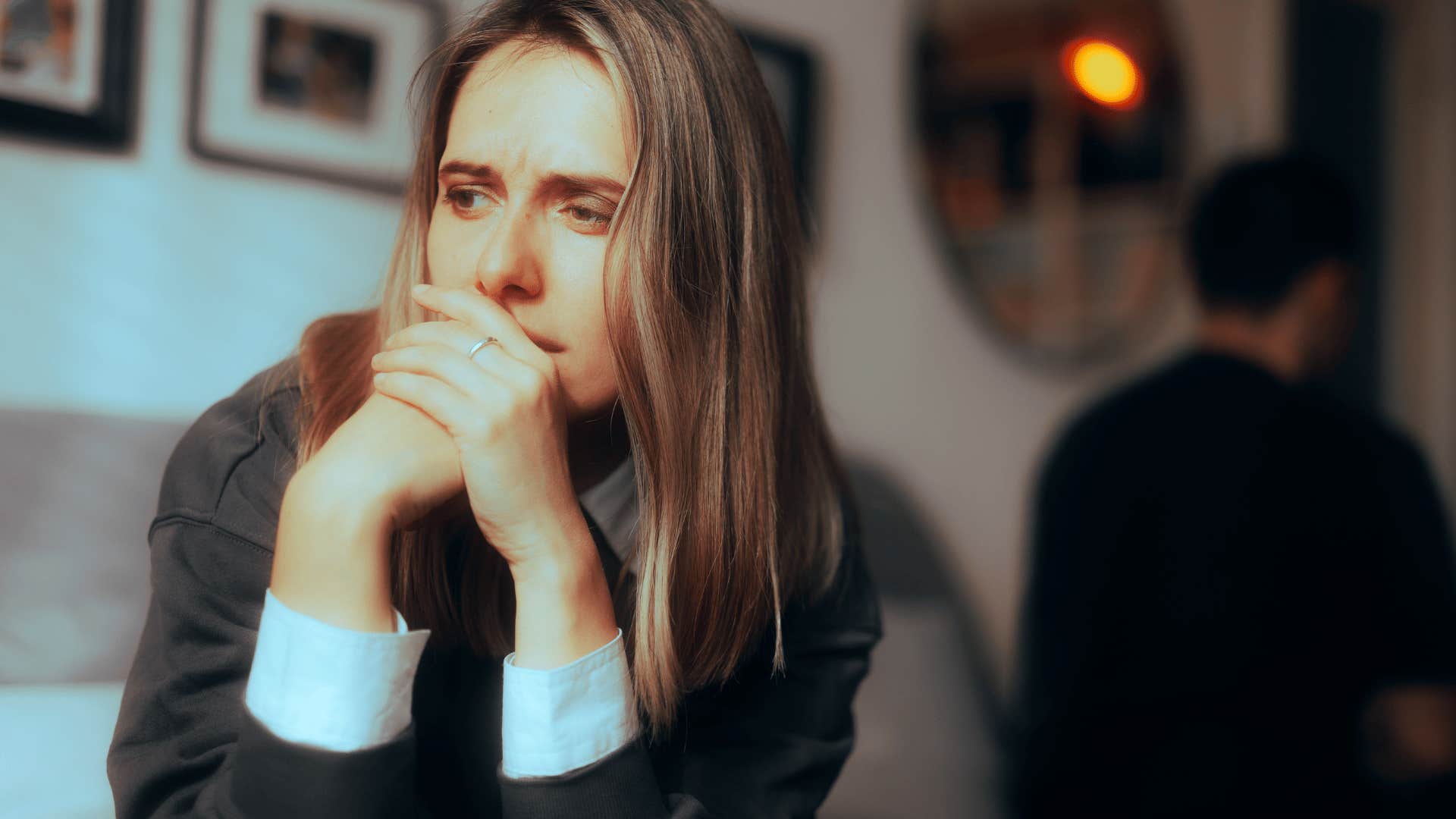 upset woman with upset man sitting behind her