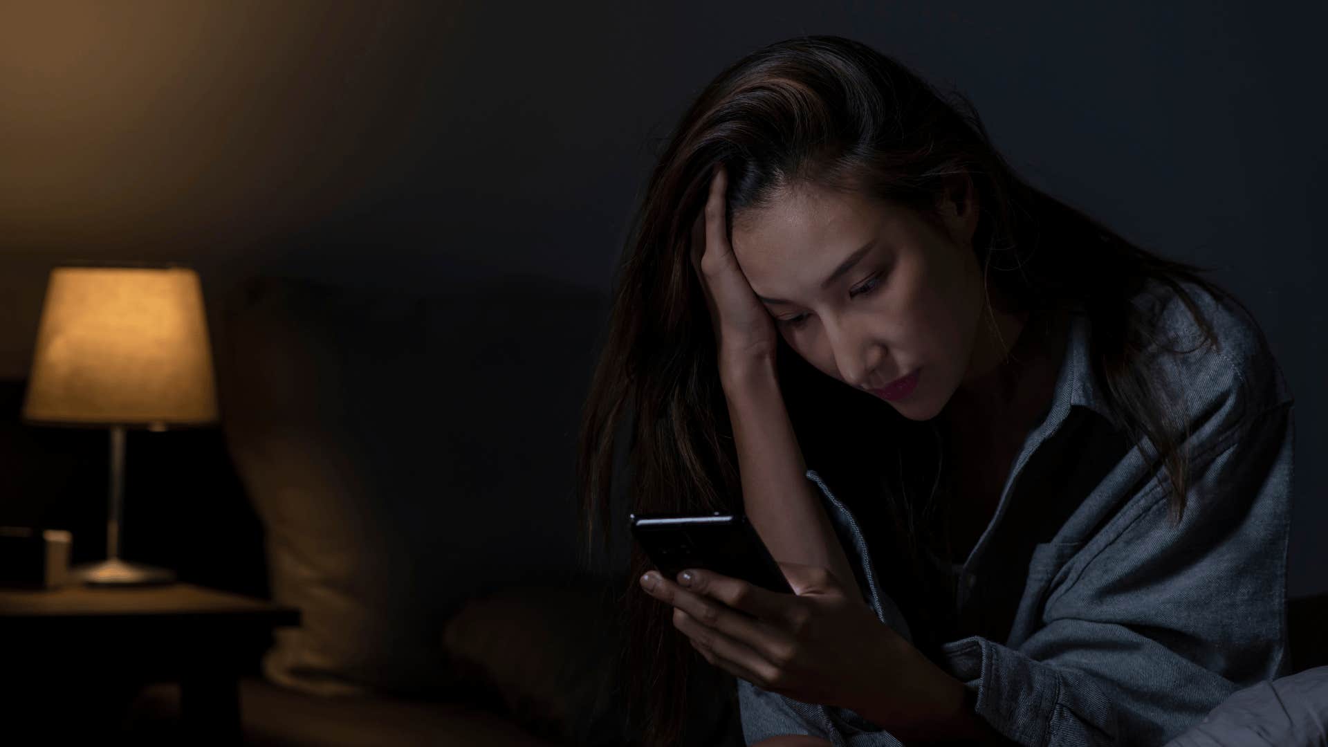 woman looking at phone at night