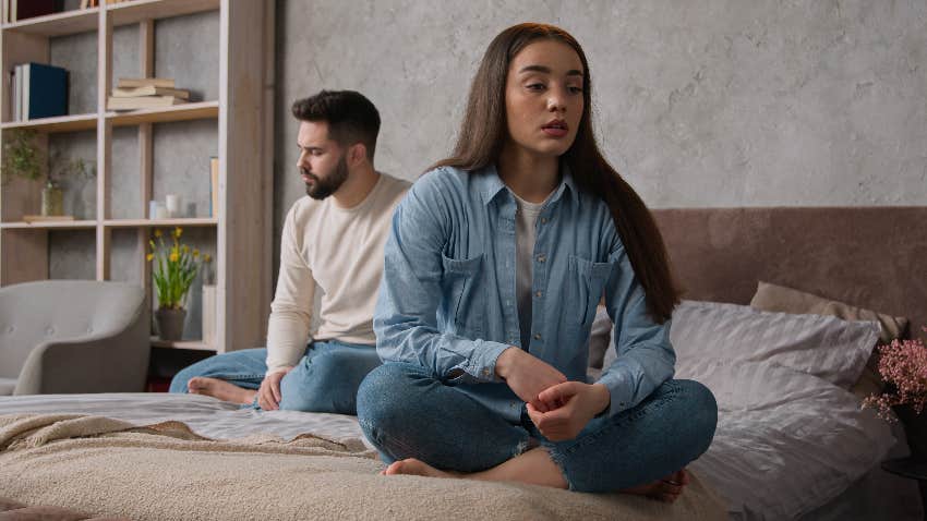 man ignoring woman on bed