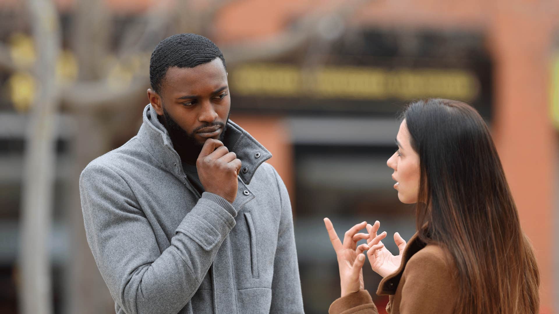 man listening to woman outside