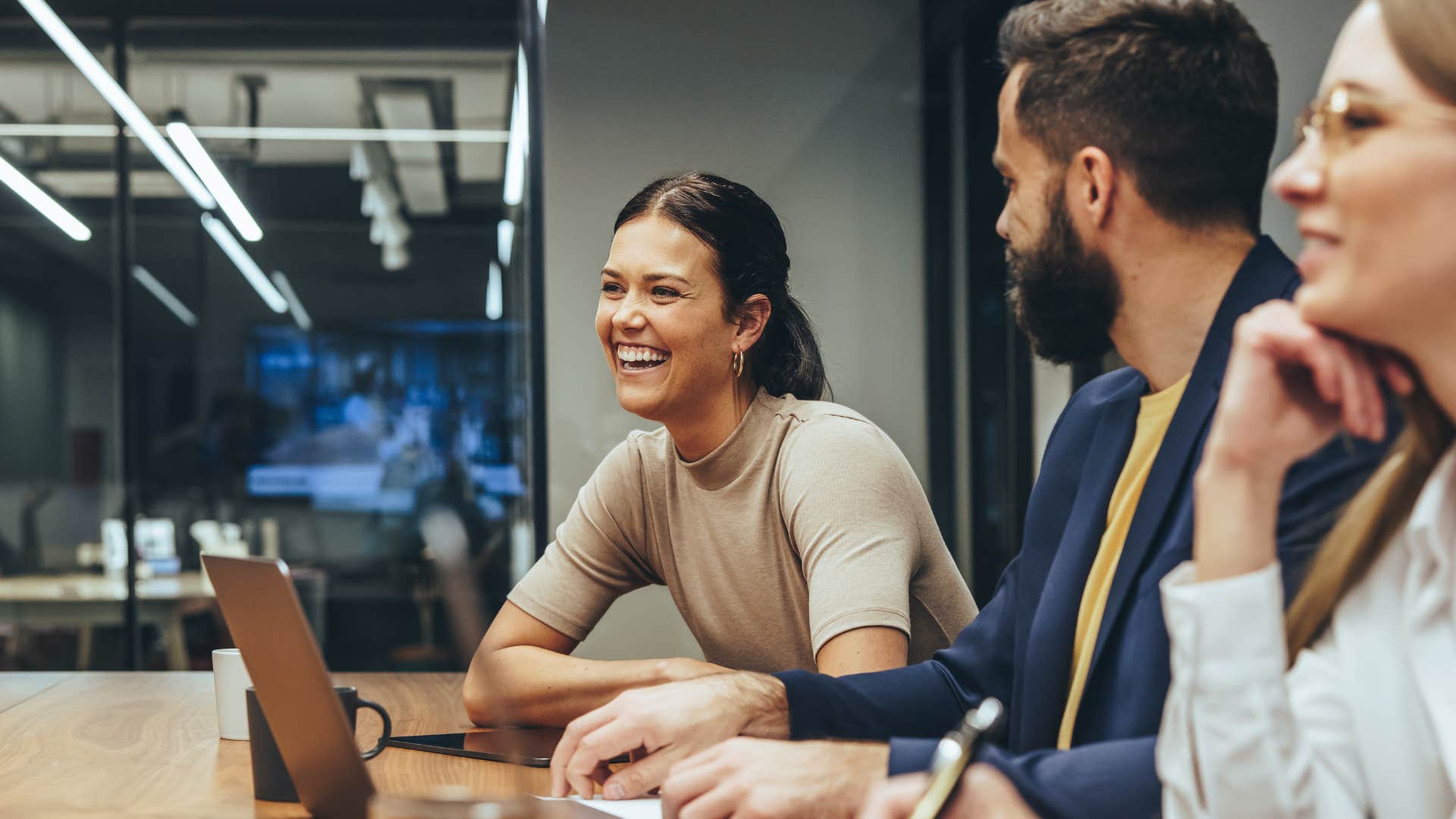 Professional woman laughing in a meeting with her colleagues