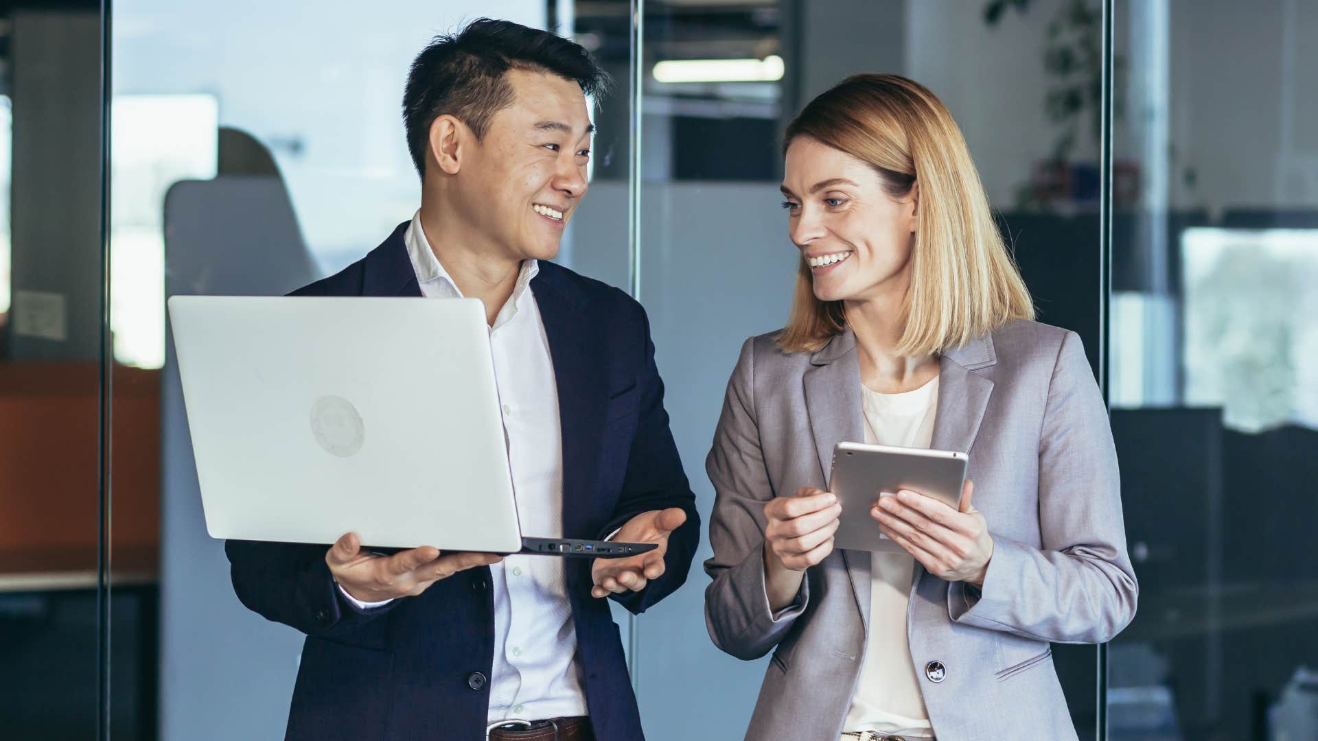 Colleagues smiling and walking together in an office