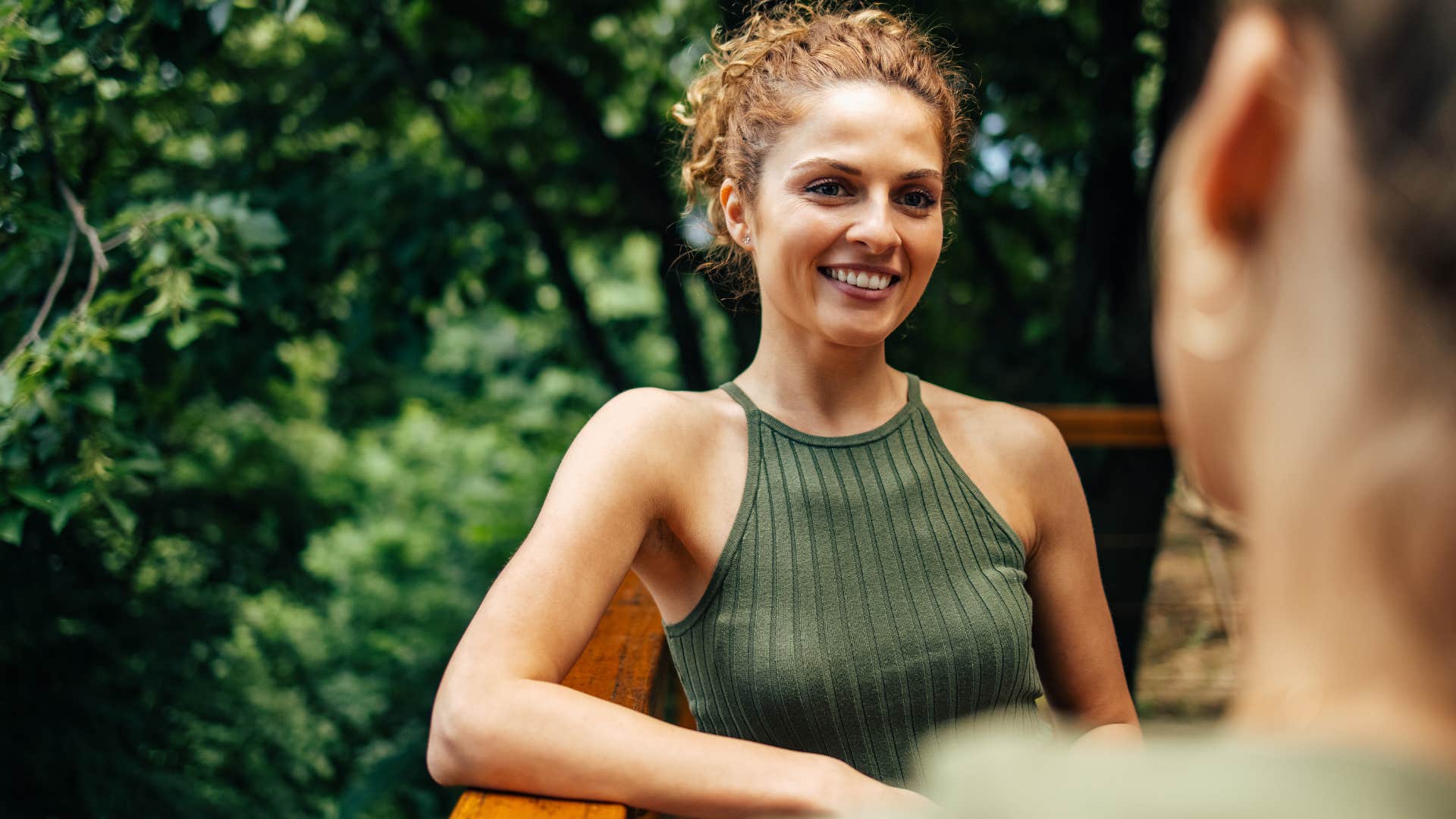 Woman smiling while talking to another person