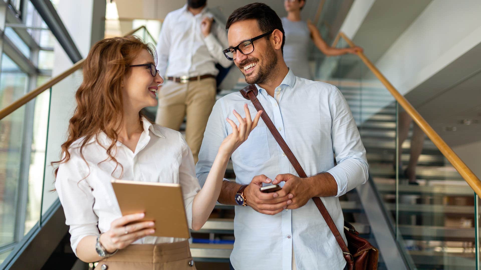 Man and woman smiling and talking to each other at work