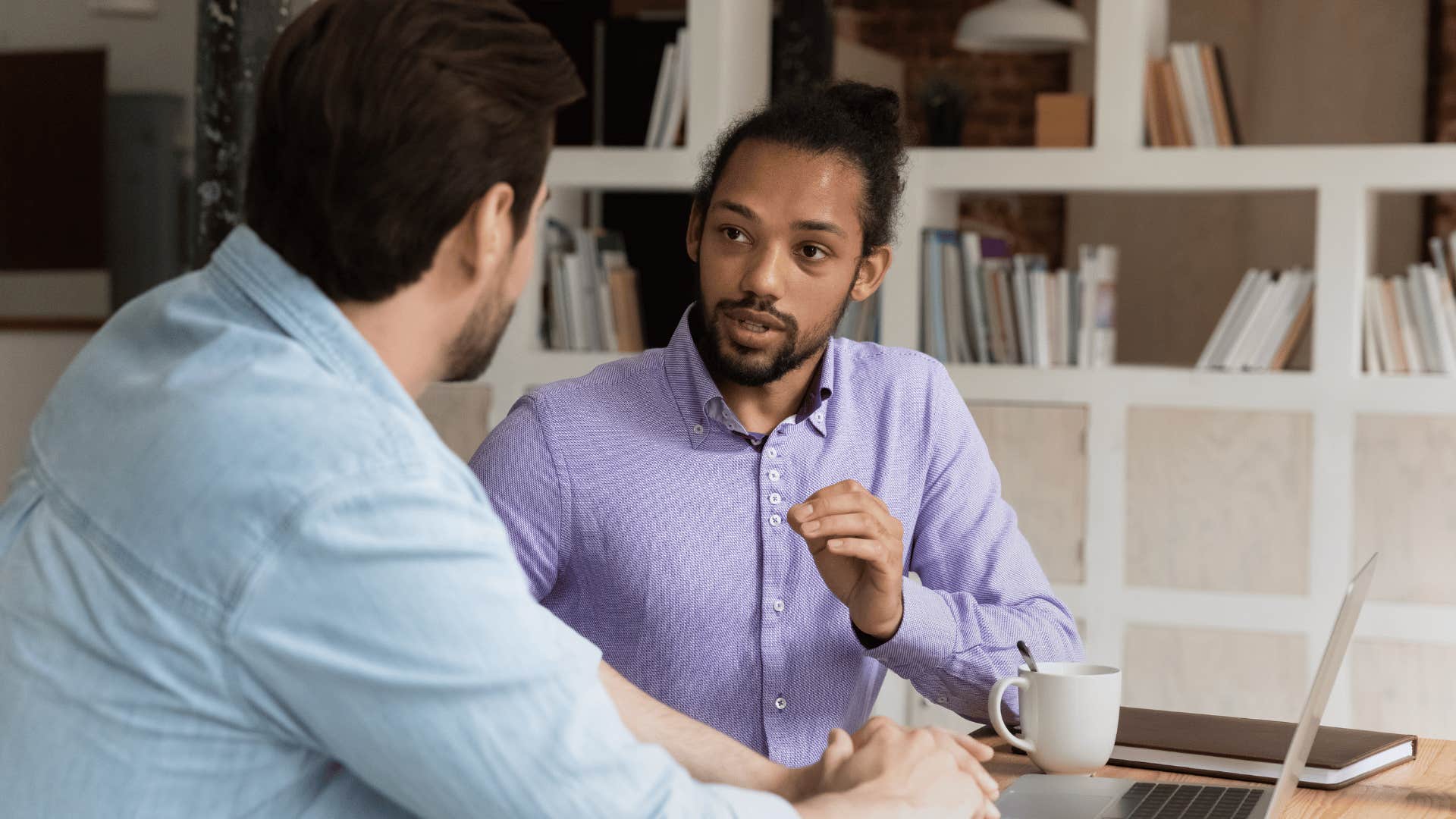 man explaining something to other man coworker