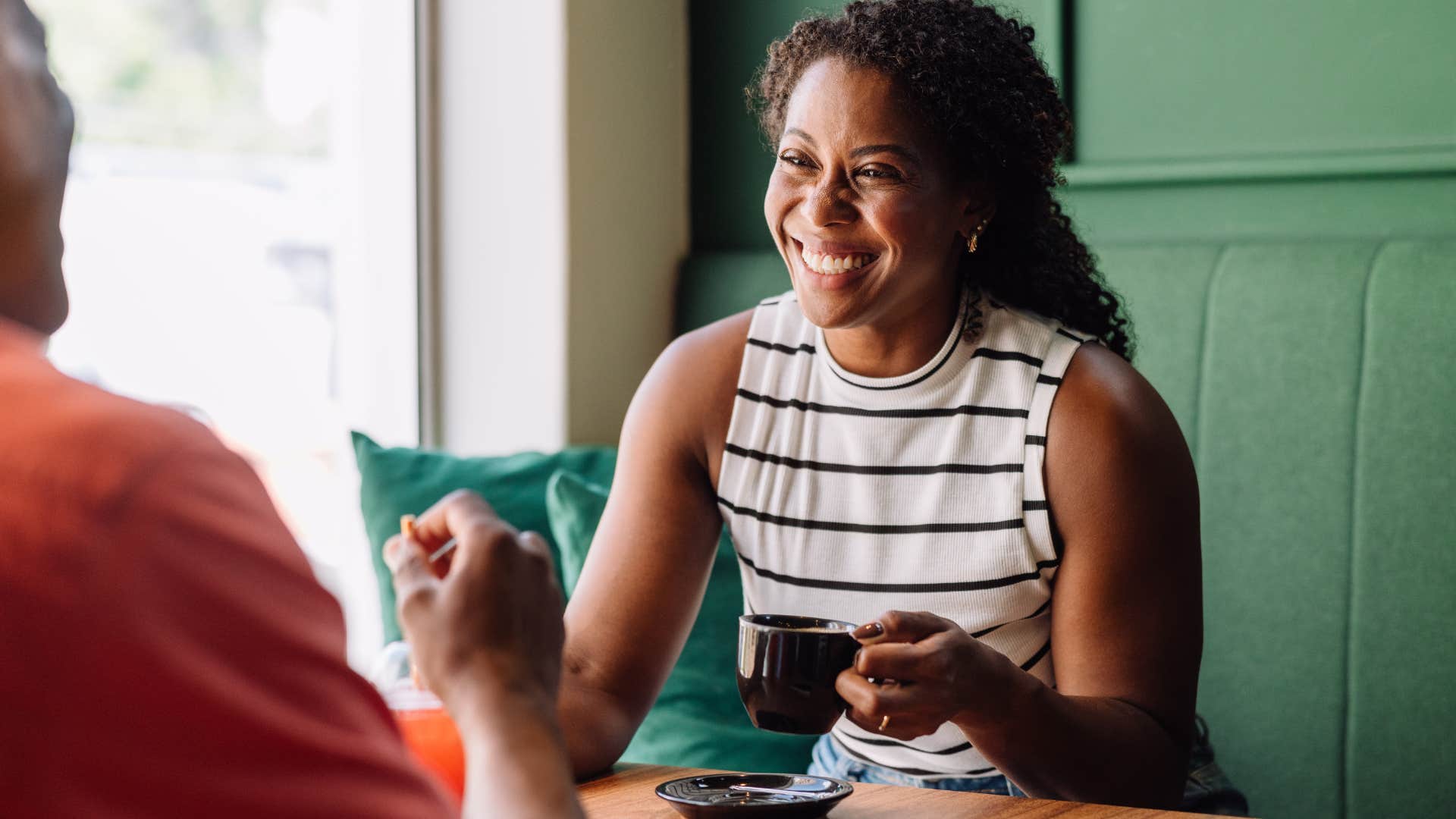 Woman smiling while talking to a man