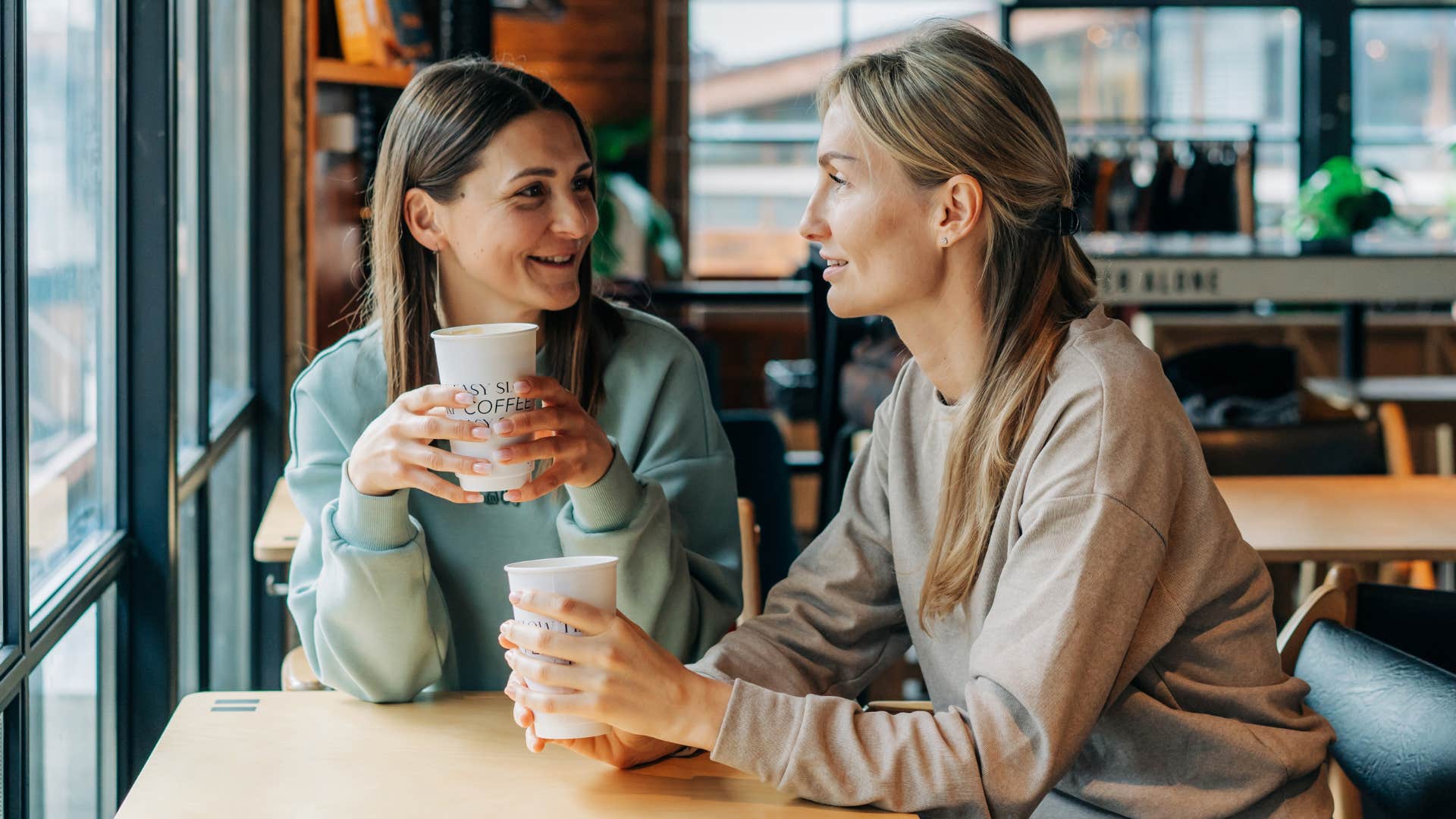 Two women having a conversation in a coffee shop. 