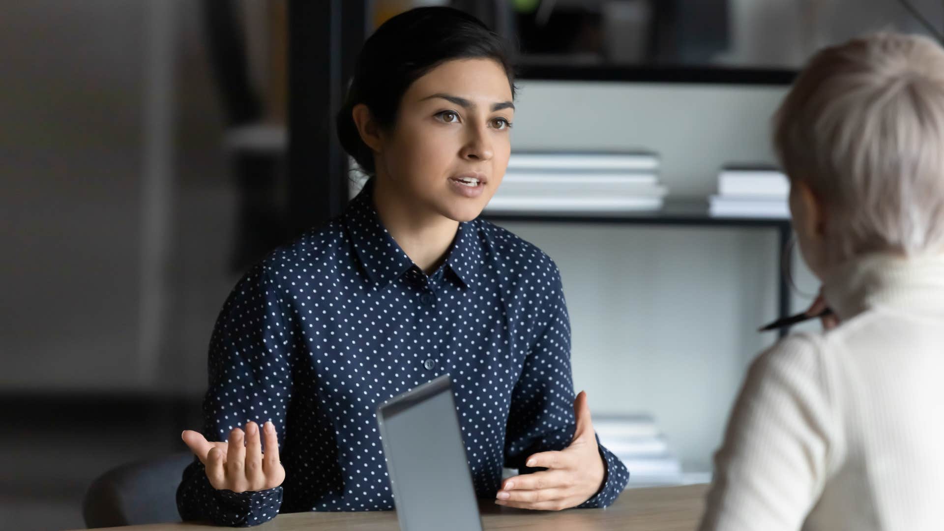 Woman having a serious conversation with a co-worker.