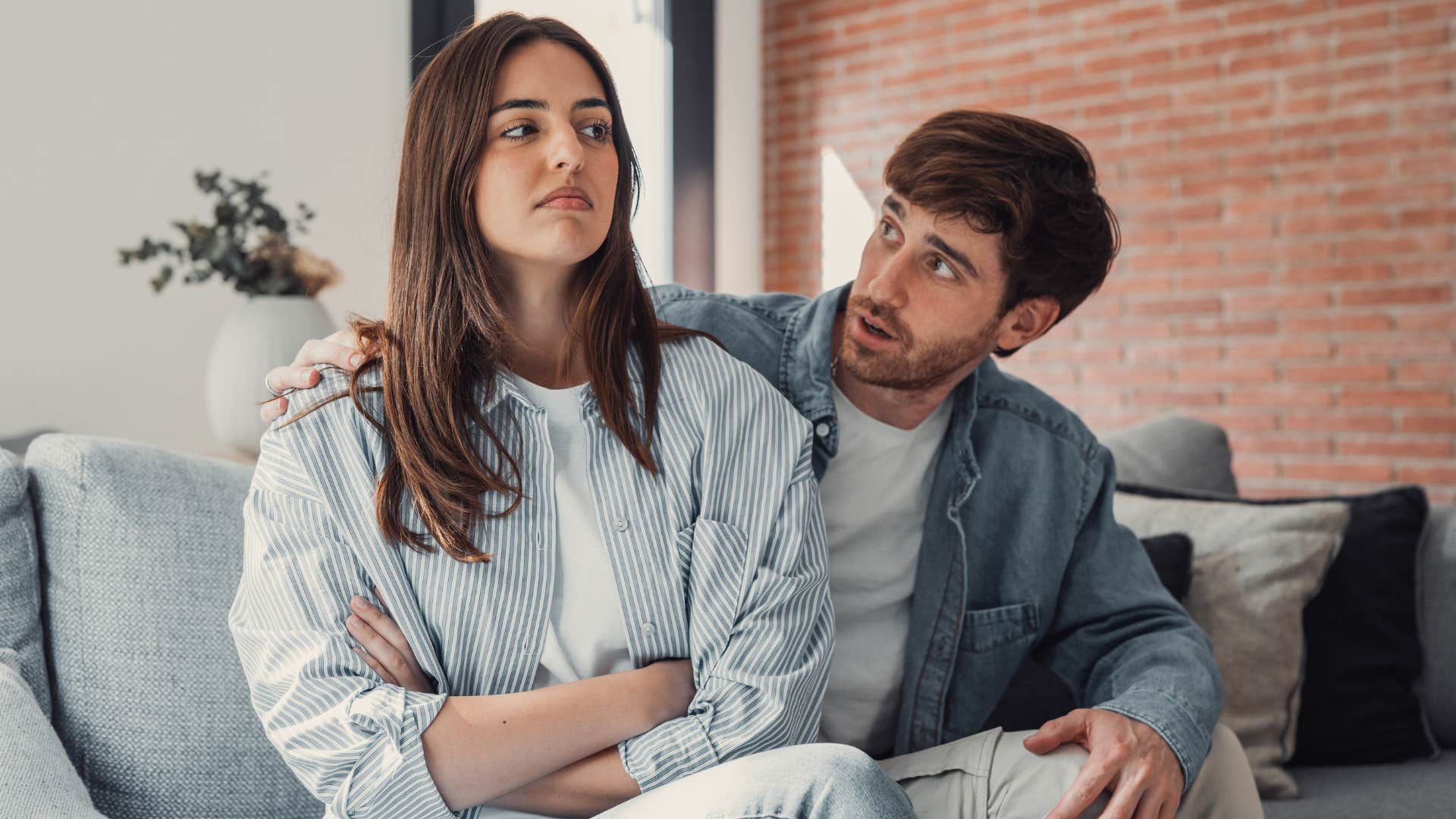 Couple arguing while sitting on a couch.