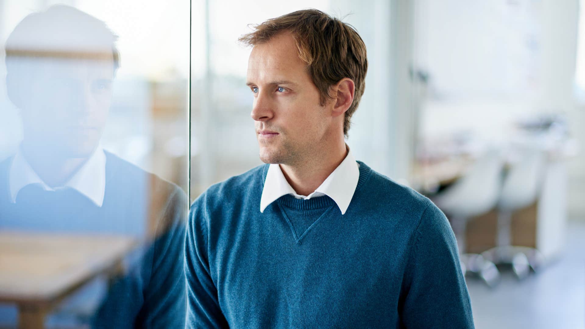 man thinking while looking at window