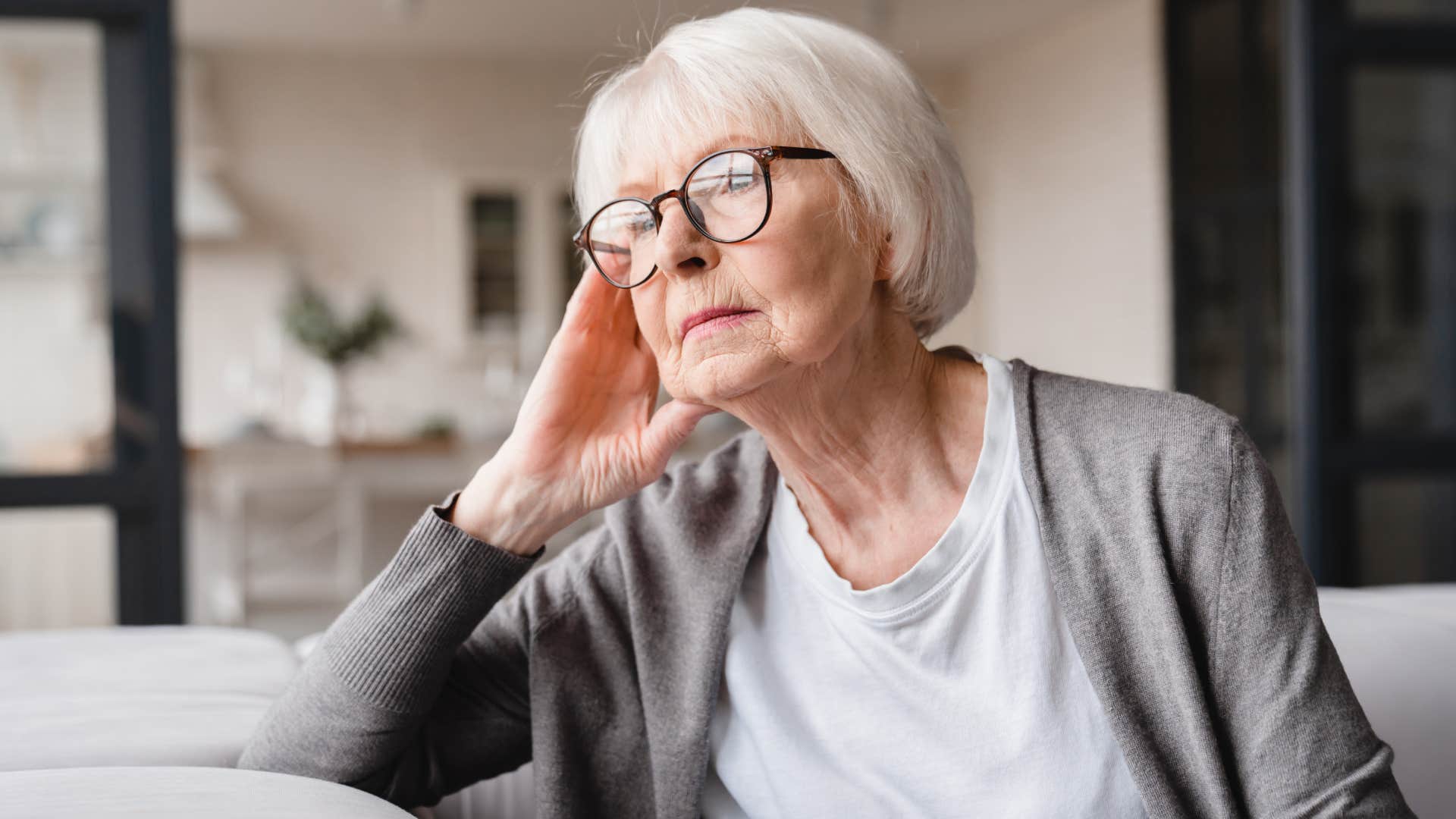 unhappy elderly woman sitting on couch