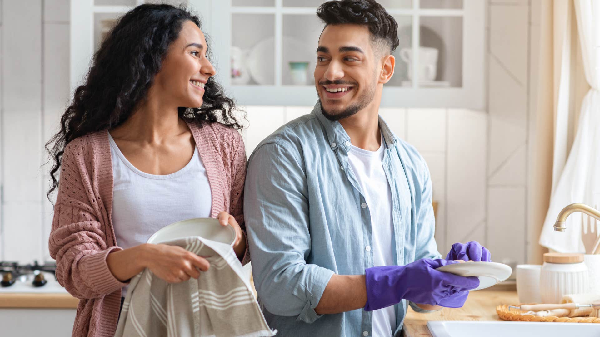 Couple smiling and doing dishes together