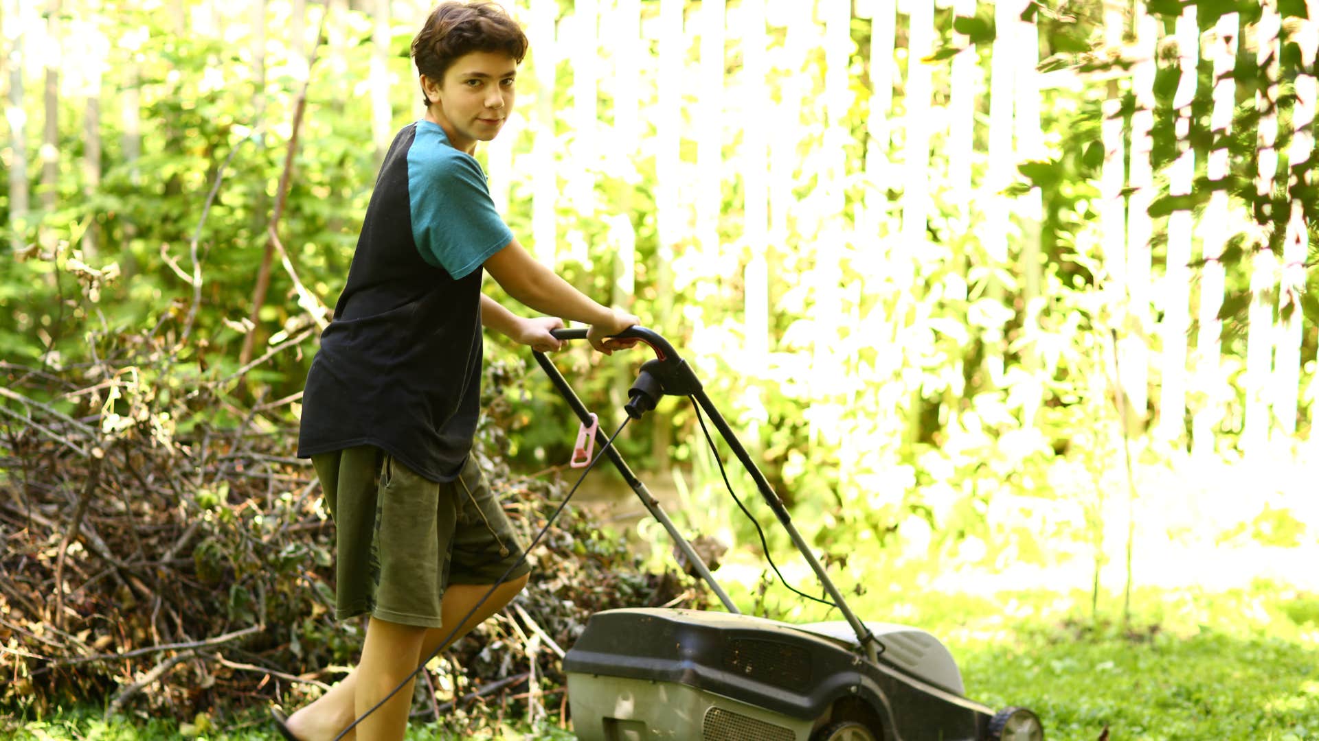 Little boy mowing the lawn