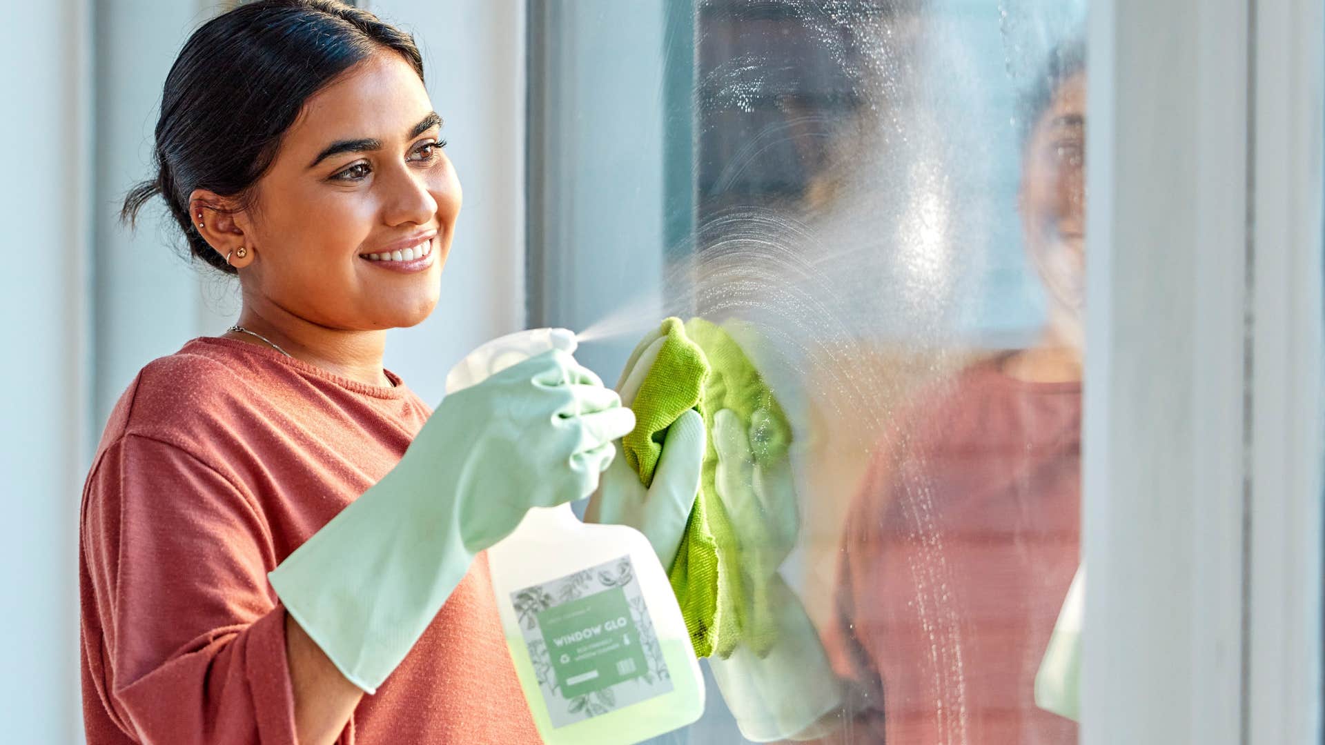 Woman smiling and cleaning her windows