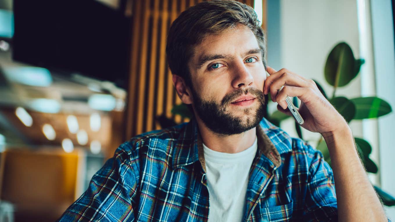 bearded man in checkered shirt sitting in cafe