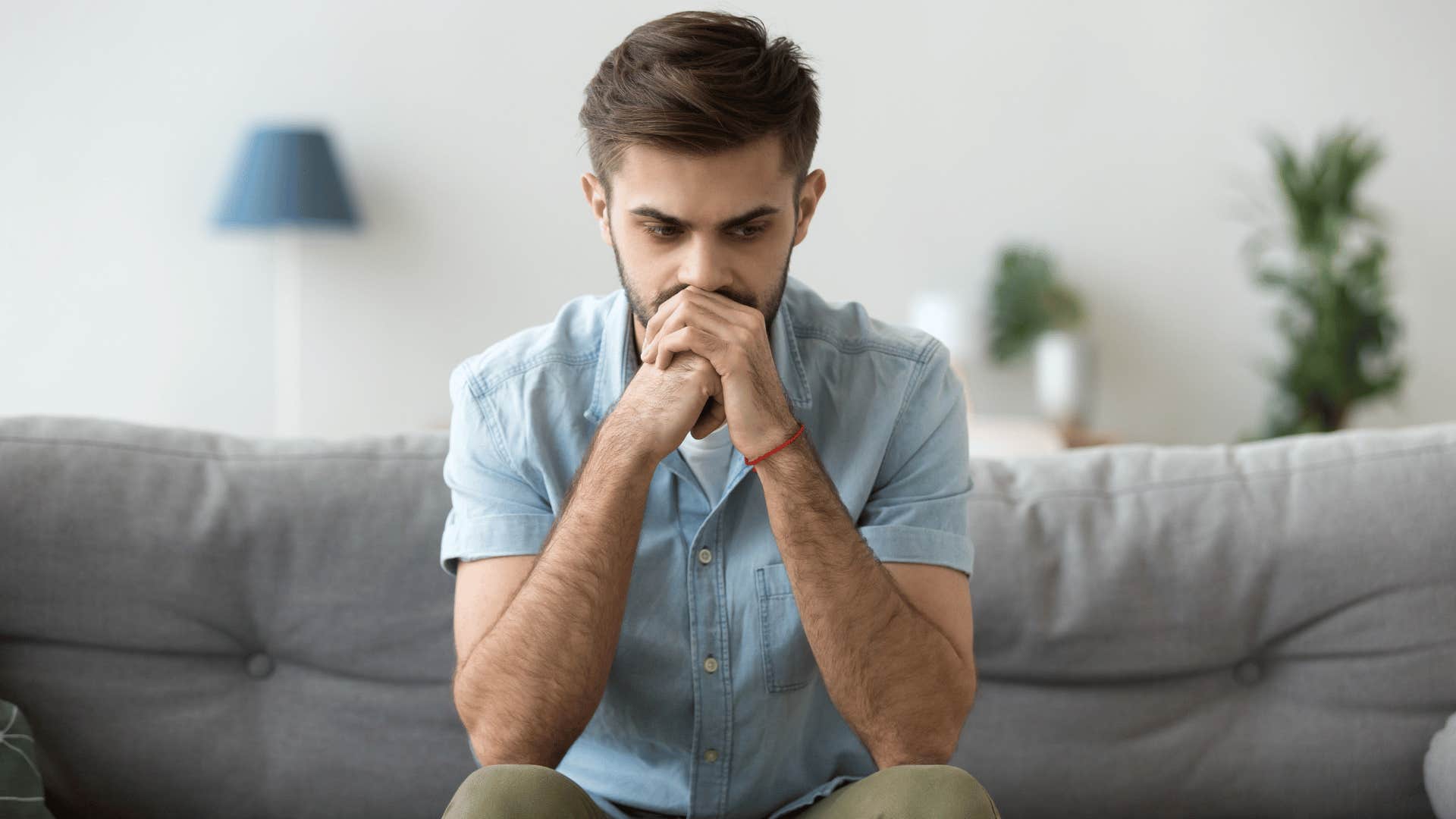 man thinking hard while sitting on couch