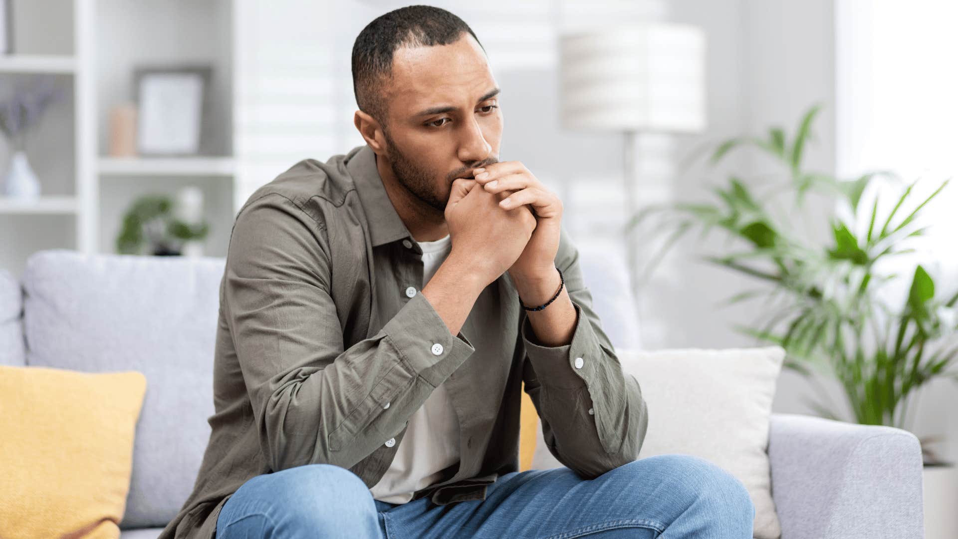 man thinking while sitting on couch