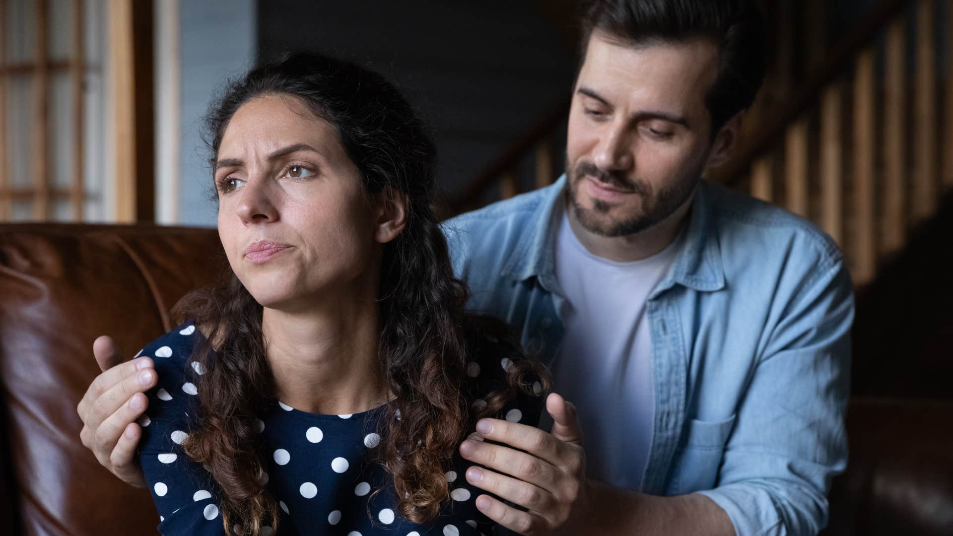 Man comforting his upset wife at home.