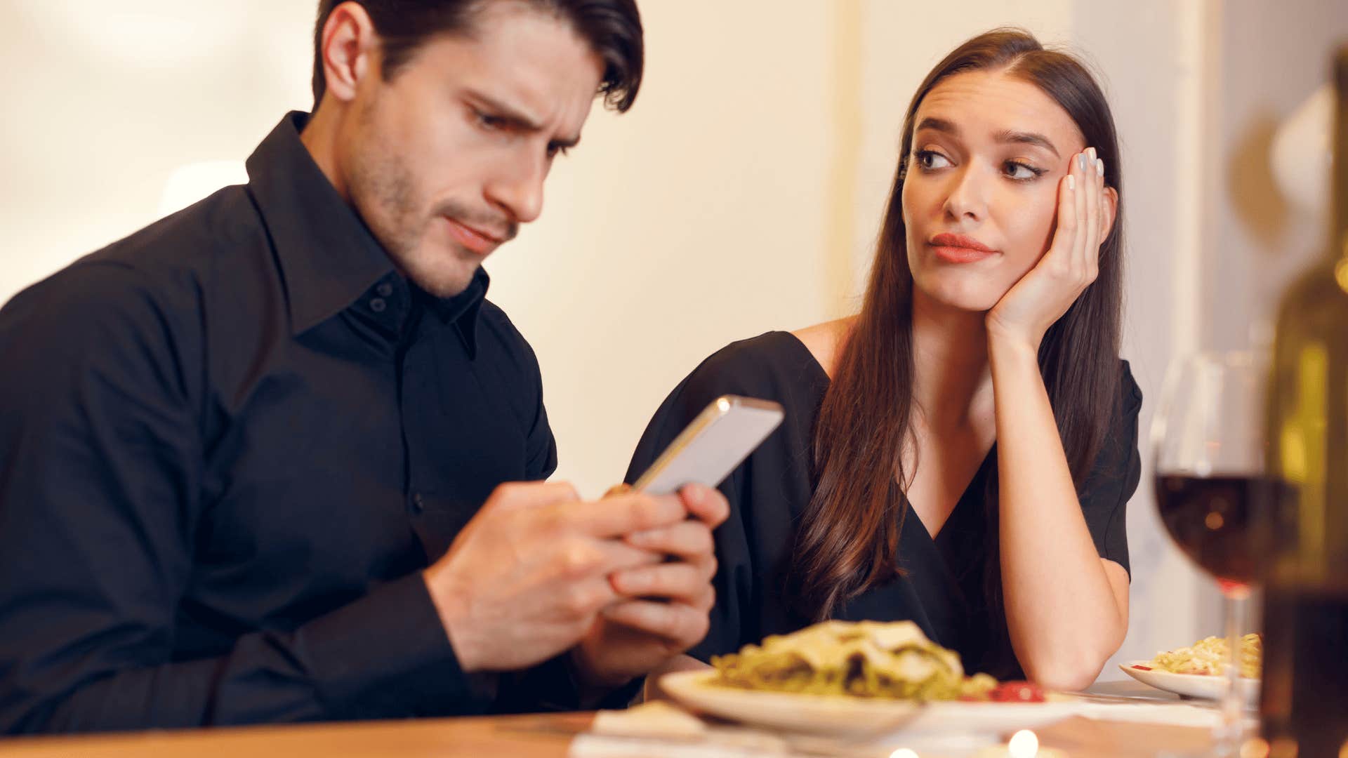 man ignoring woman on date