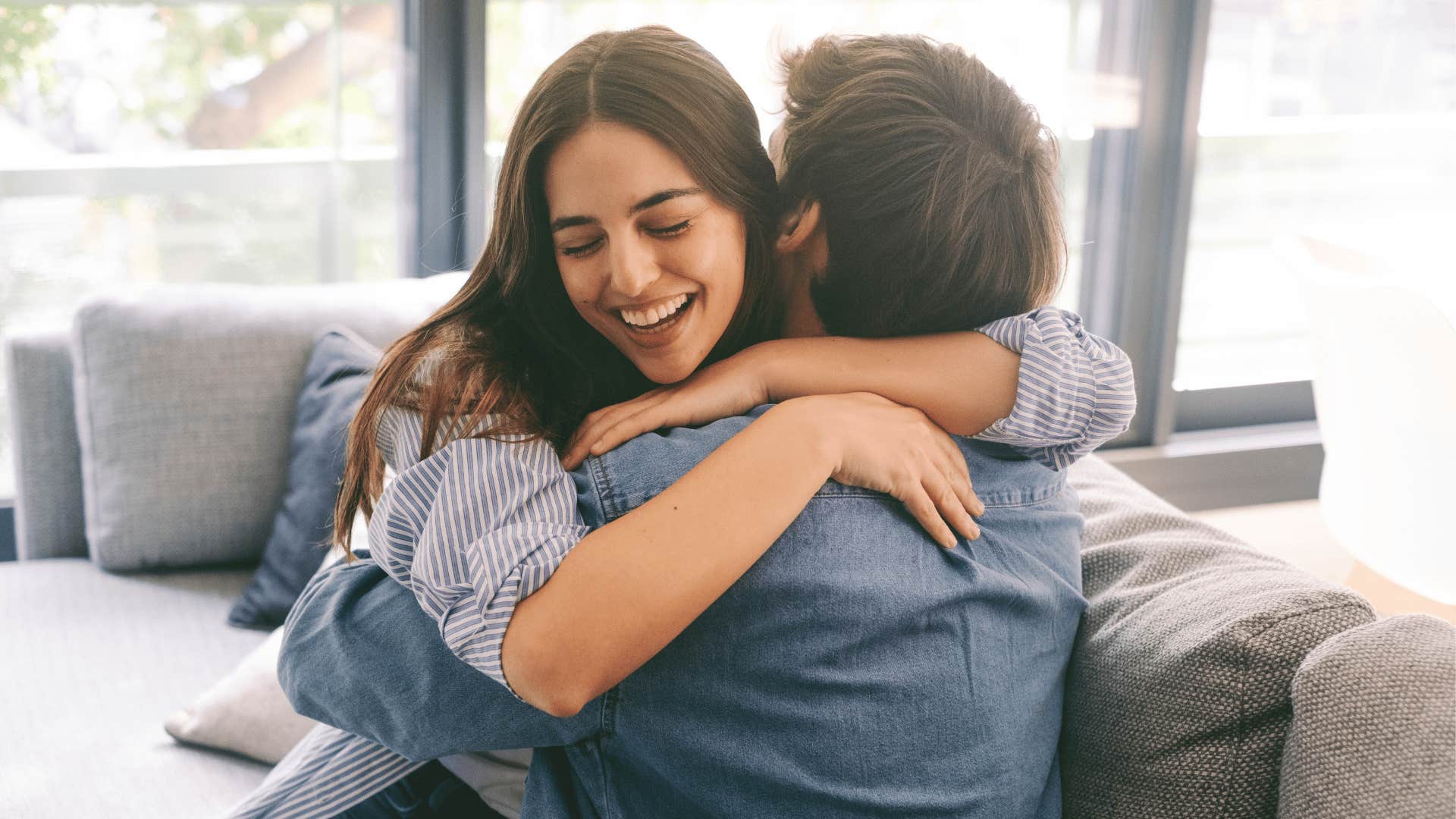 woman hugging man on couch