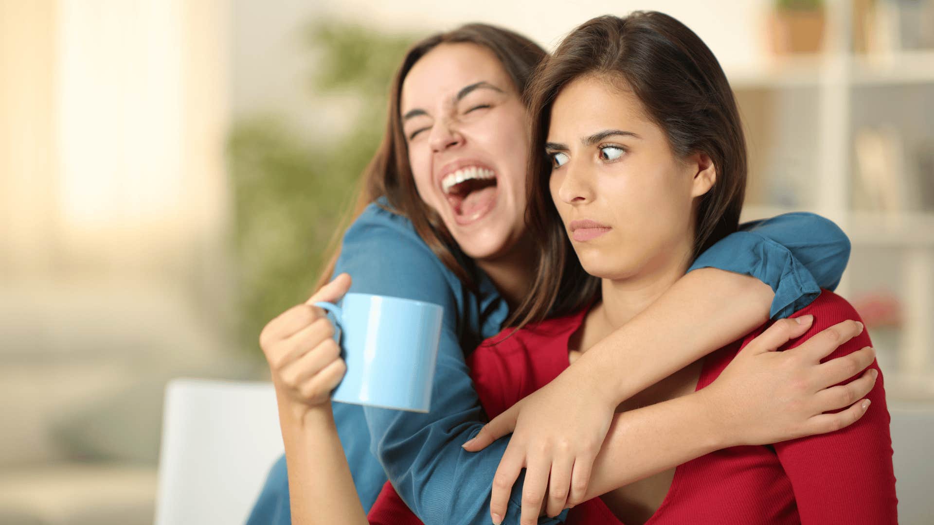 woman uncomfortable as another woman hugs her