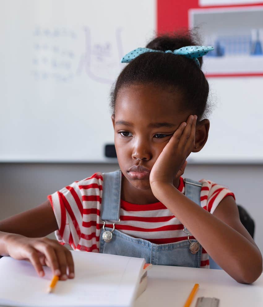 Sad girl in classroom, tired of parents complaininga about ex