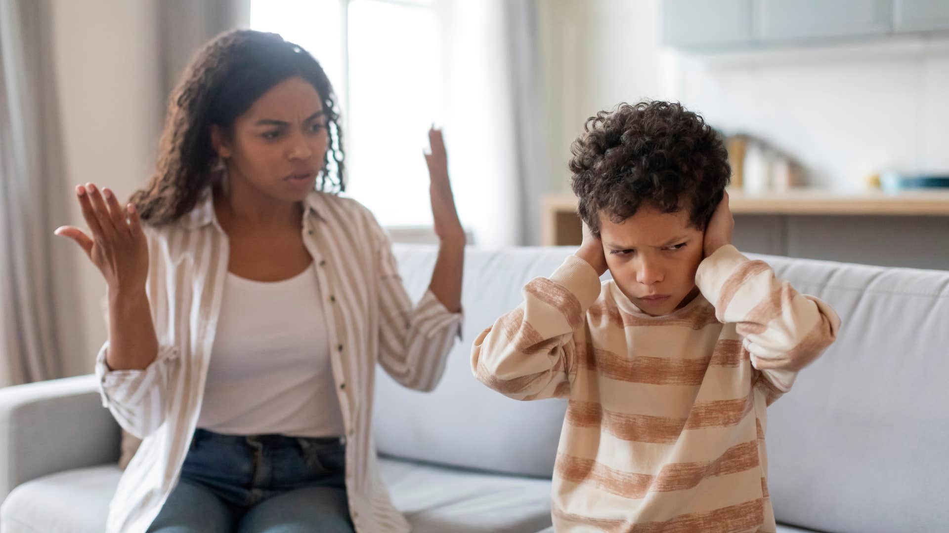 entitled boy covering his ears while mom speaks