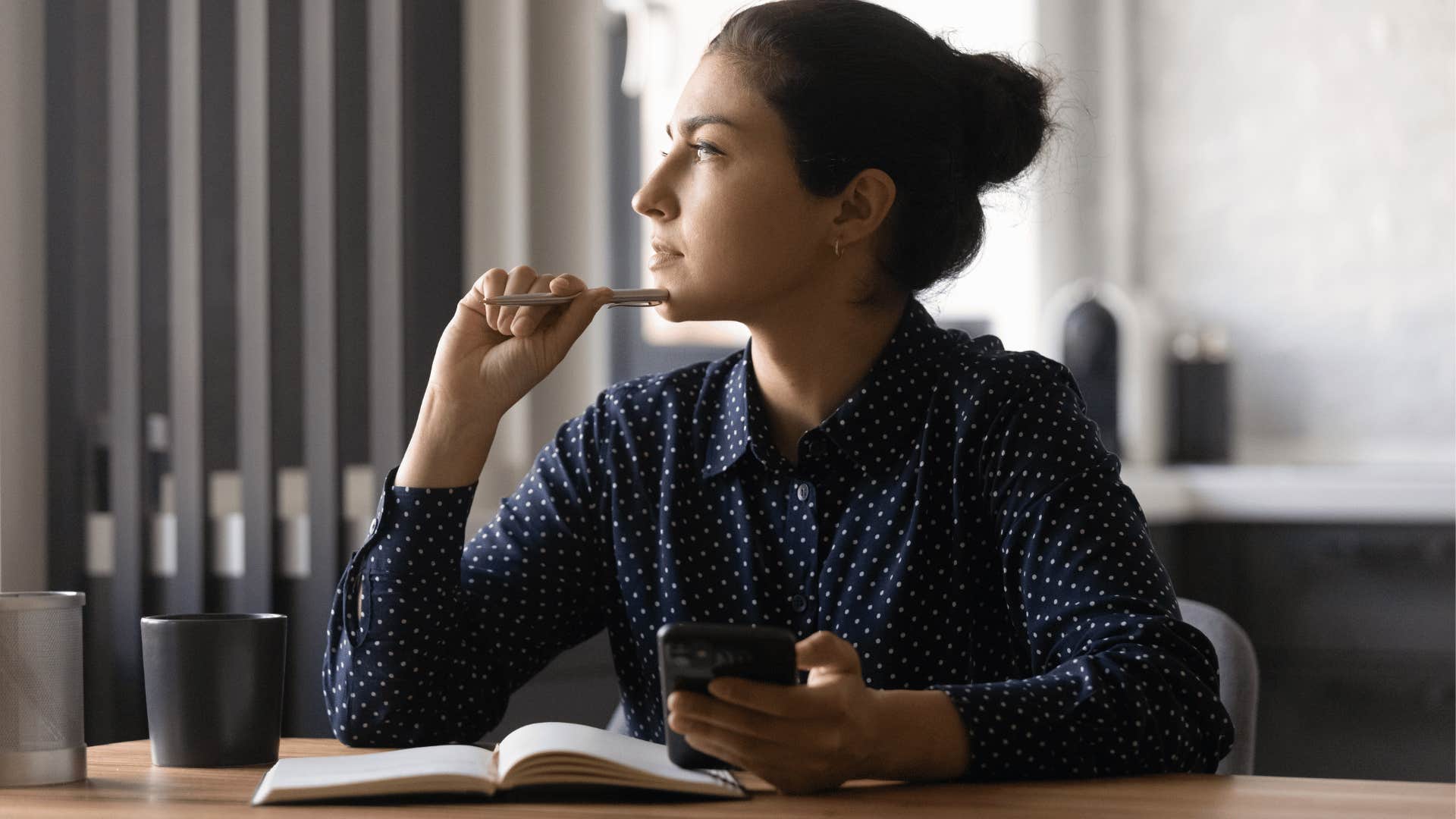 woman taking notes and thinking