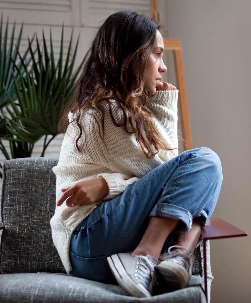 Nervous woman sits sideways in chair