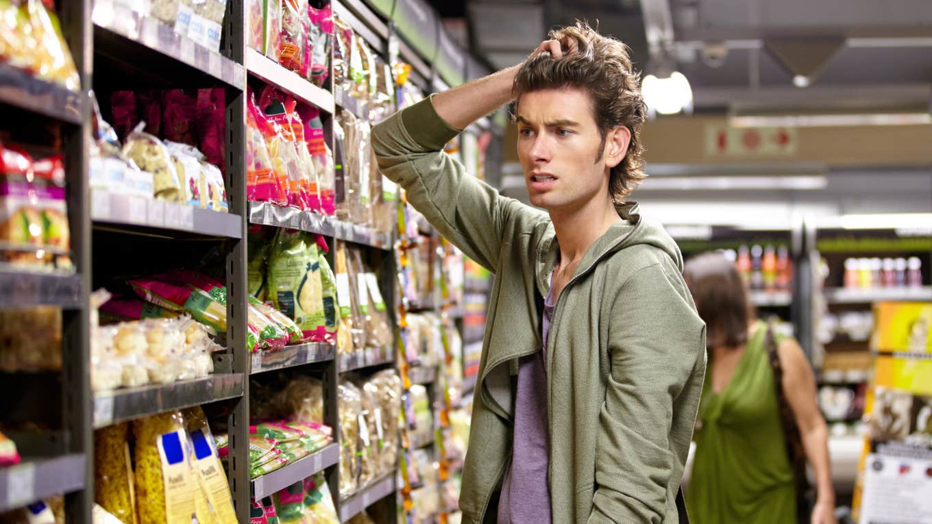 Confused man shopping for groceries