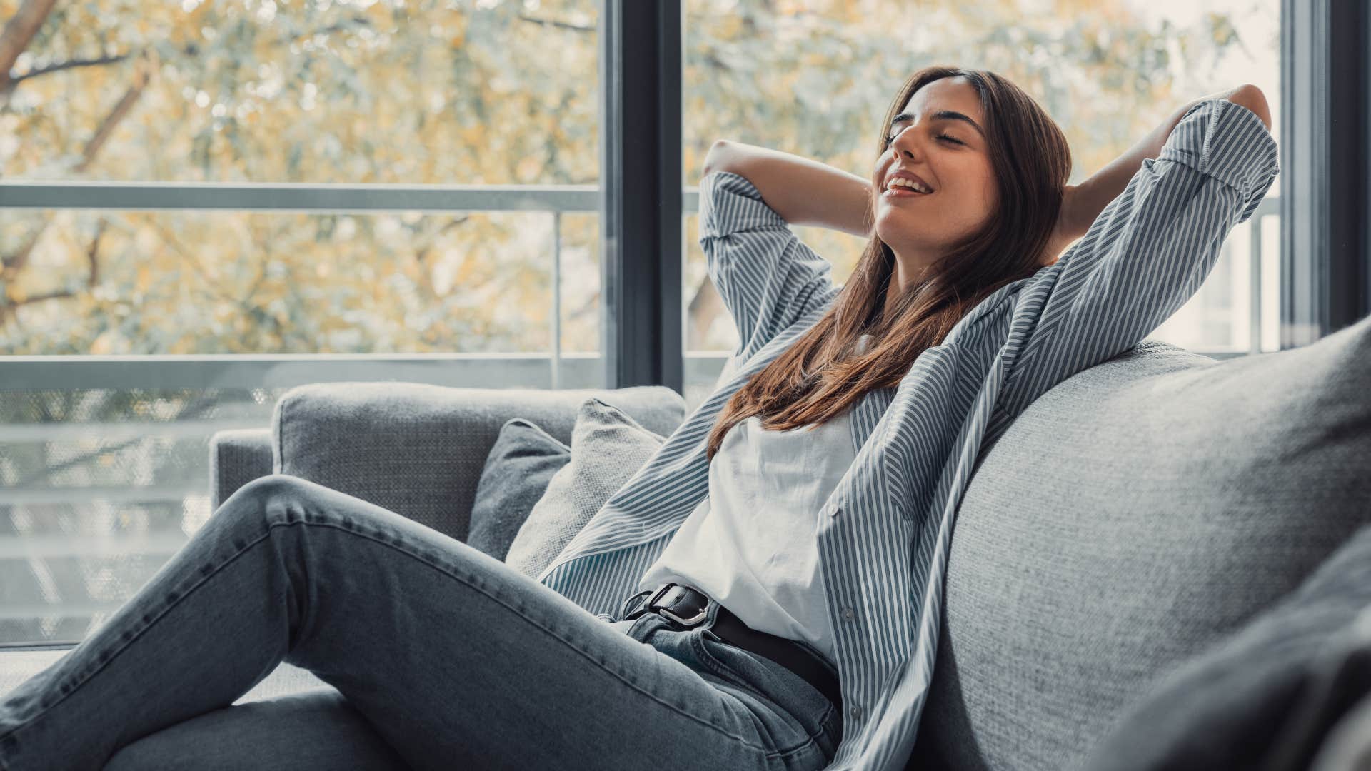 woman relaxing on couch next to window