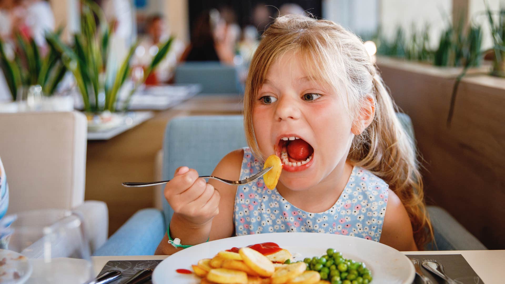 Little girl eating in restaurant