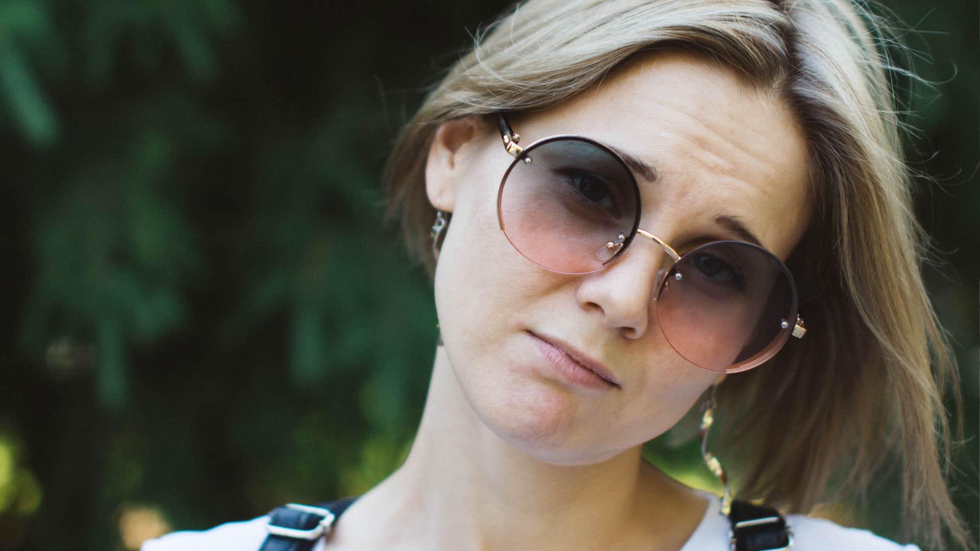 Closeup portrait of a sad young woman. Sad look of a pretty woman in sunglasses