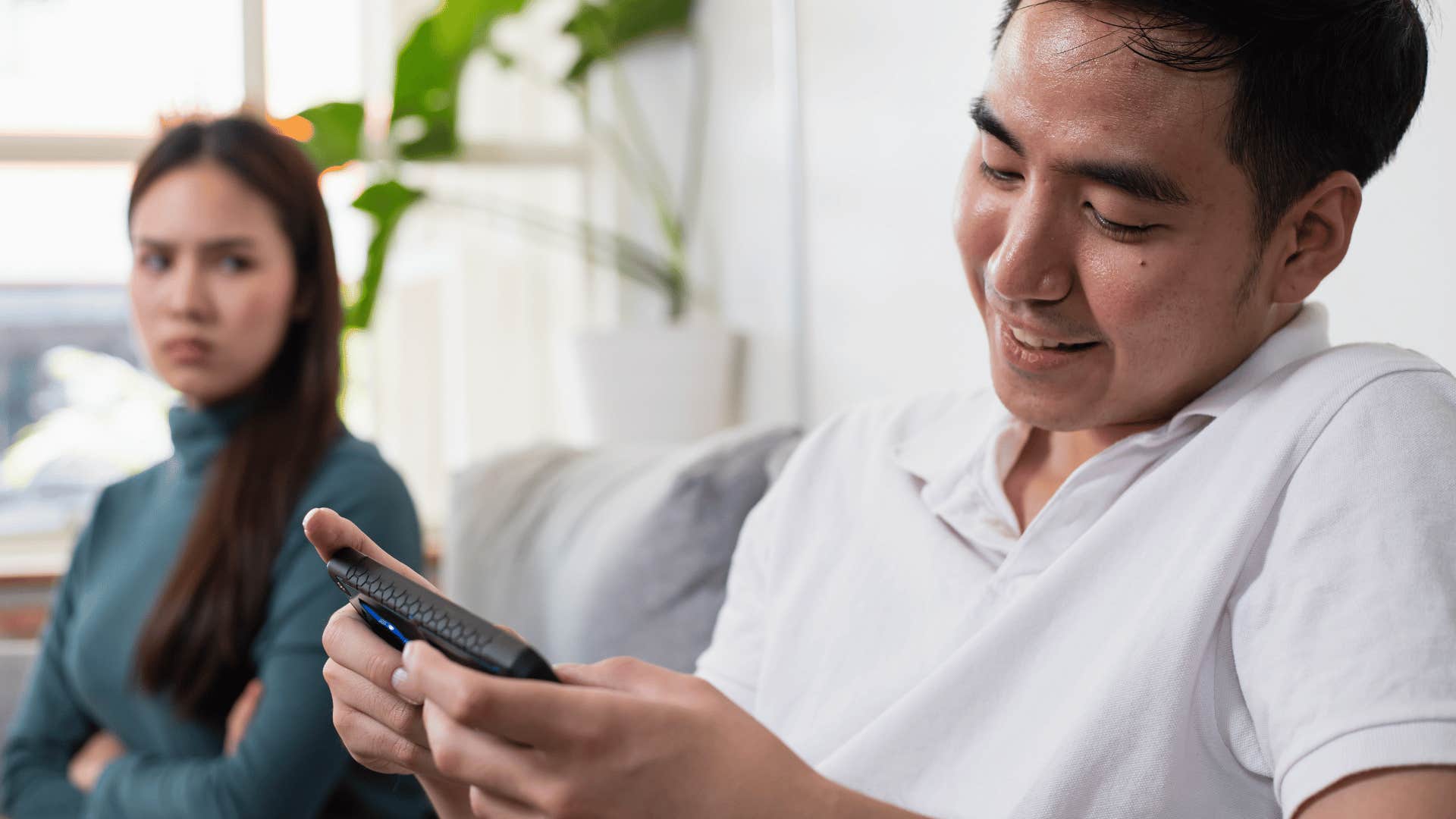 upset woman looking at man on his phone