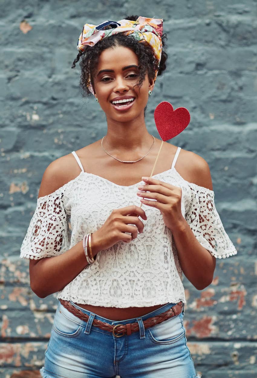 woman smiling and holding a heart 