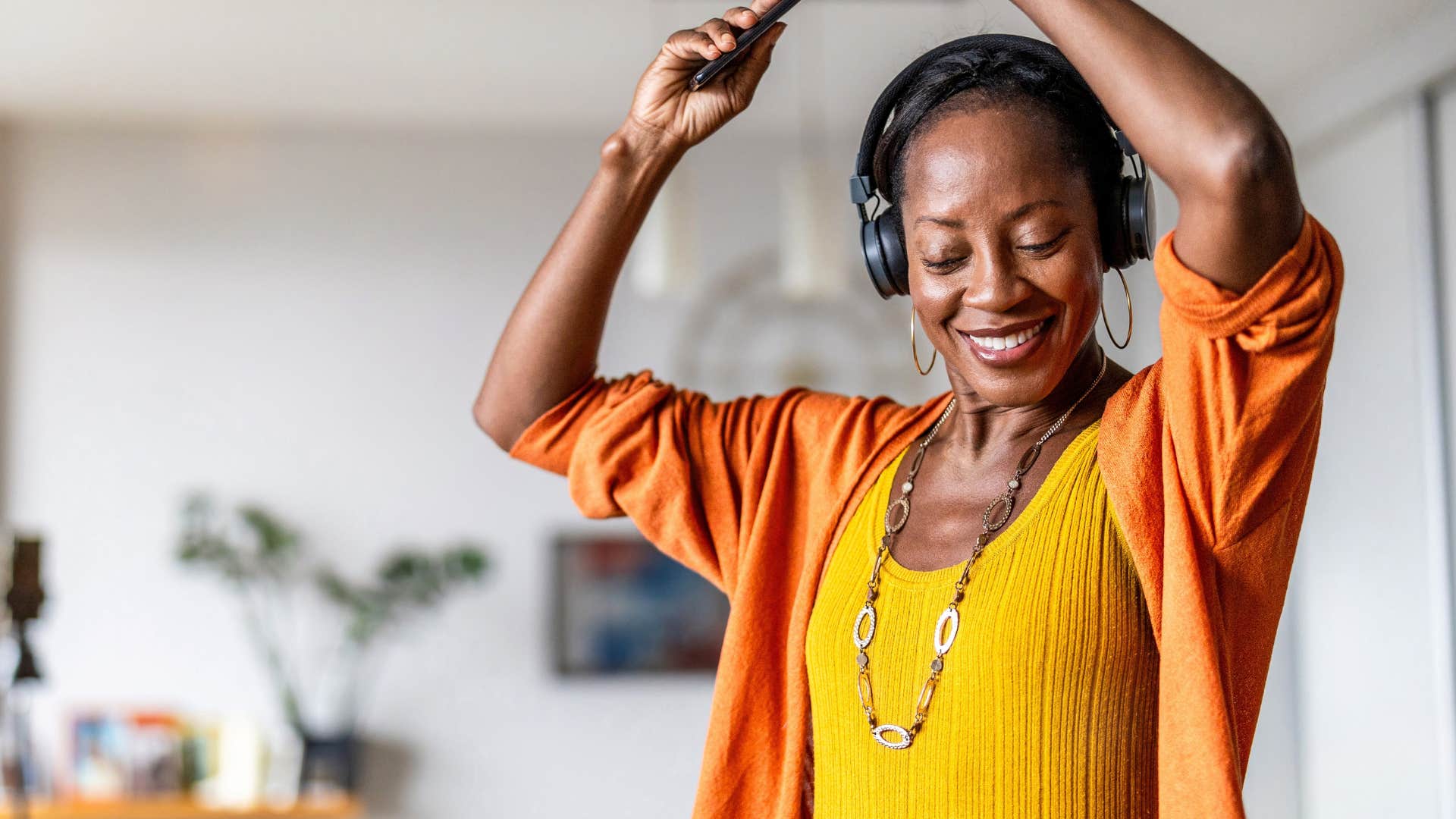 Woman dancing while listening to music in her headphones.