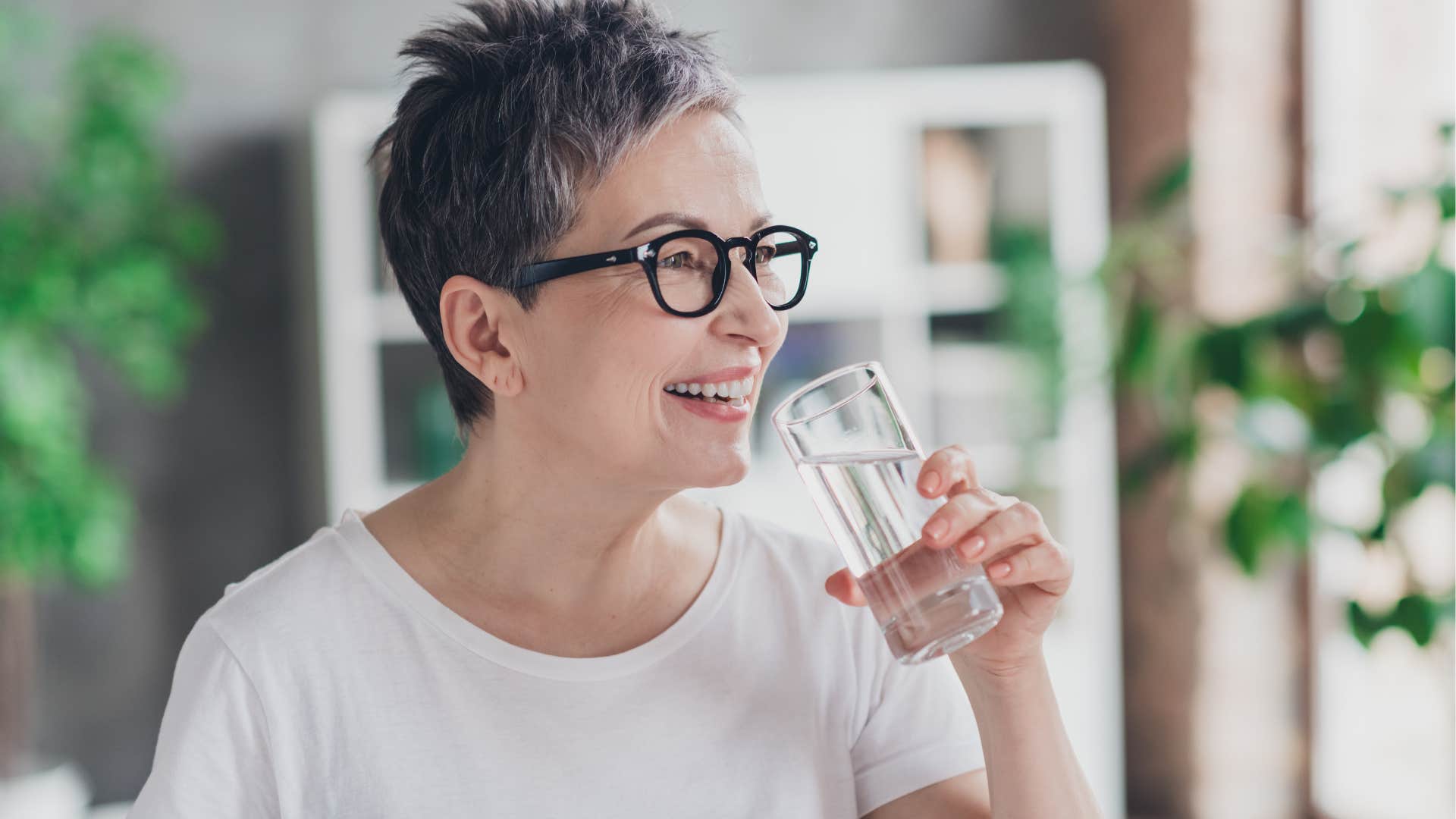 Woman smiling and drinking water.